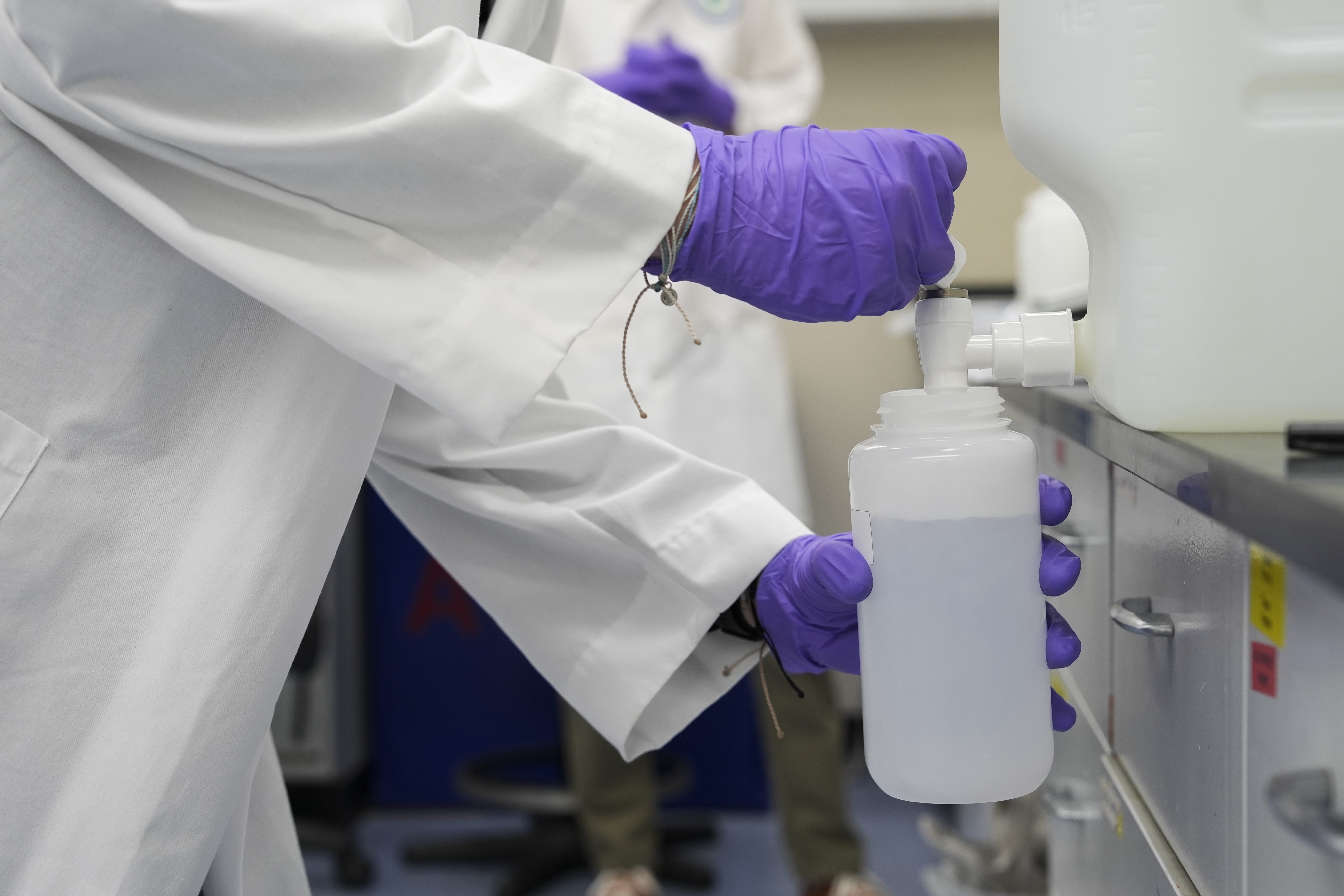 Logan Feeney pours a water sample with forever chemicals, known as PFAS, into a container for research, April 10, 2024, at a U.S. Environmental Protection Agency lab in Cincinnati.<br /> (Joshua A. Bickel / AP Photo)