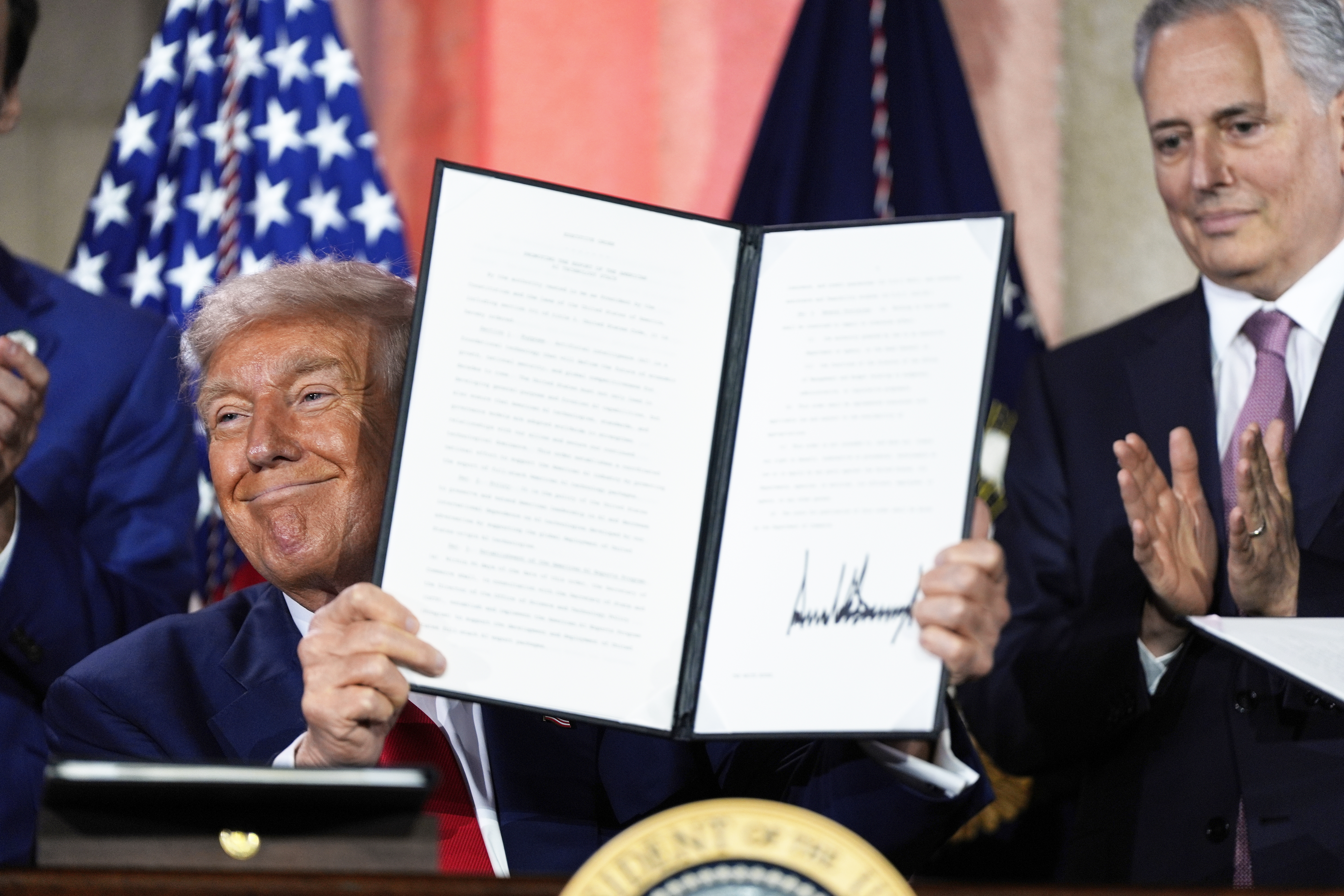 President Donald Trump holds a signed executive order after speaking during an AI summit at the Andrew W. Mellon Auditorium, Wednesday, July 23, 2025, in Washington.<br />(Julia Demaree Nikhinson / AP Photo)