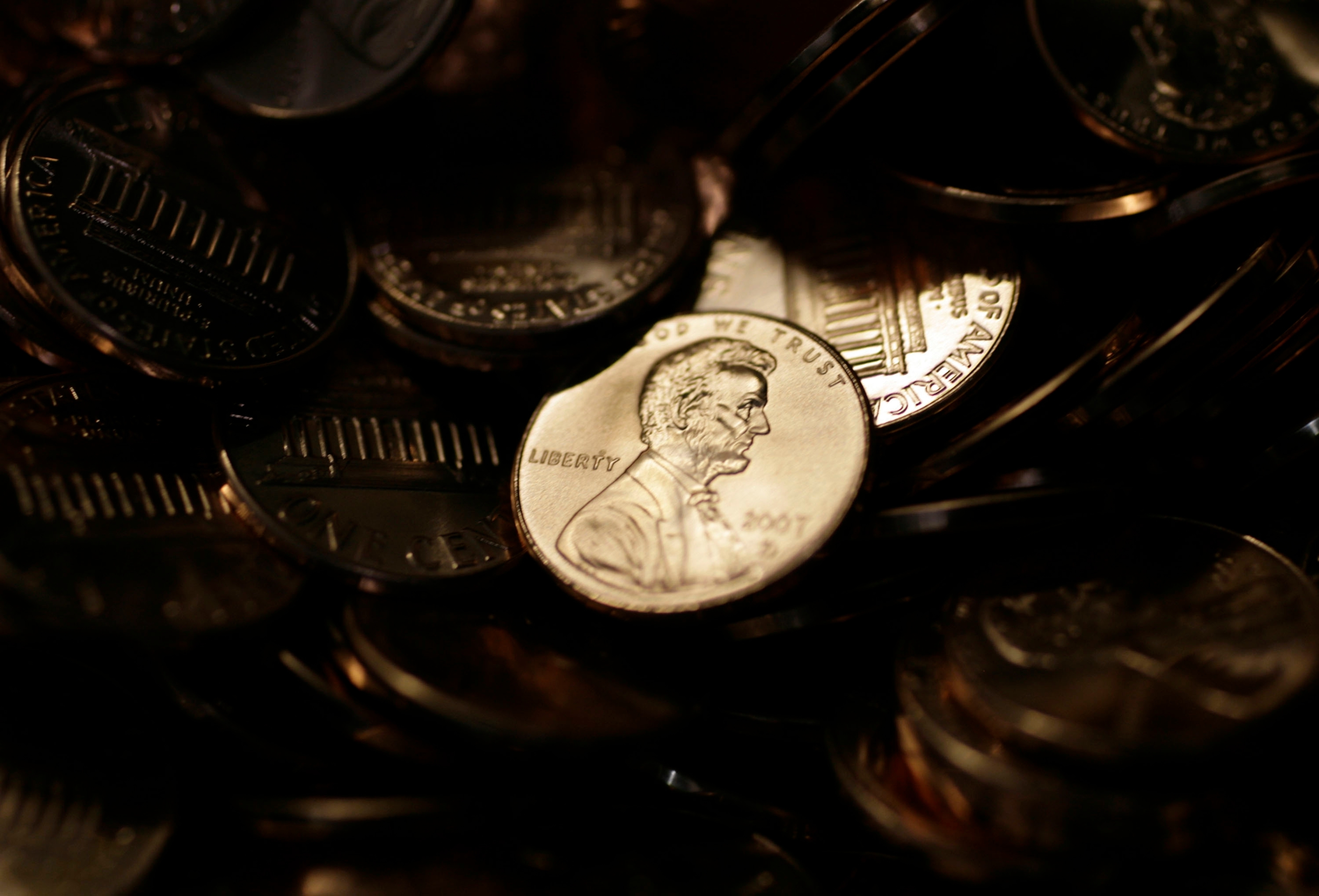 A lone penny is illuminated in a bin of completed pennies at the U.S. Mint in Denver on Aug. 15, 2007.<br />(David Zalubowski / AP Photo)