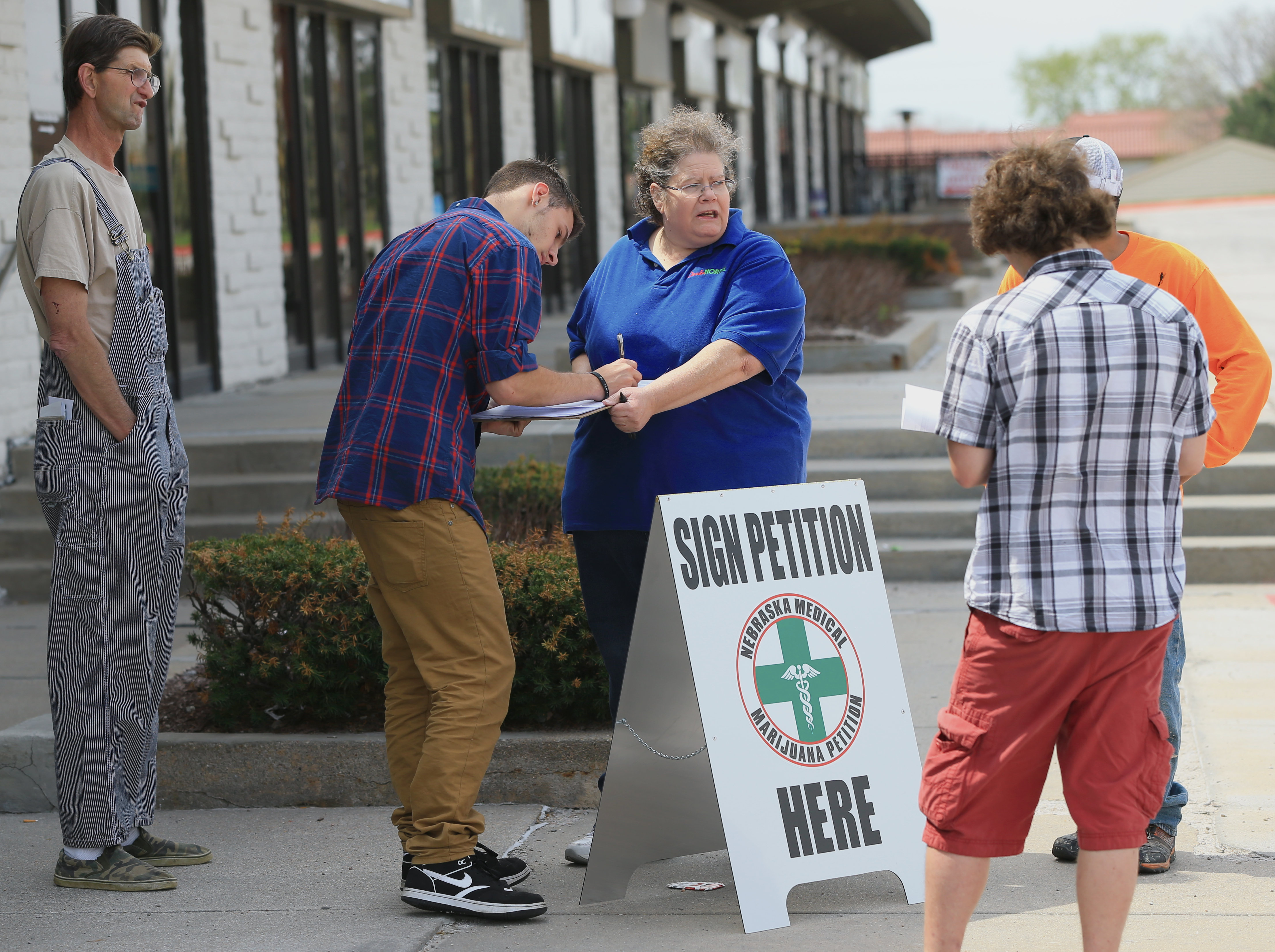 April 17, 2015, activist Maggie Graham (center) collects signatures in Omaha, Neb., for a petition to place medical marijuana on the ballot. Supporters of medical marijuana are still fighting to get it put on the ballot this year.<br />(Nati Harnik / AP Photo)