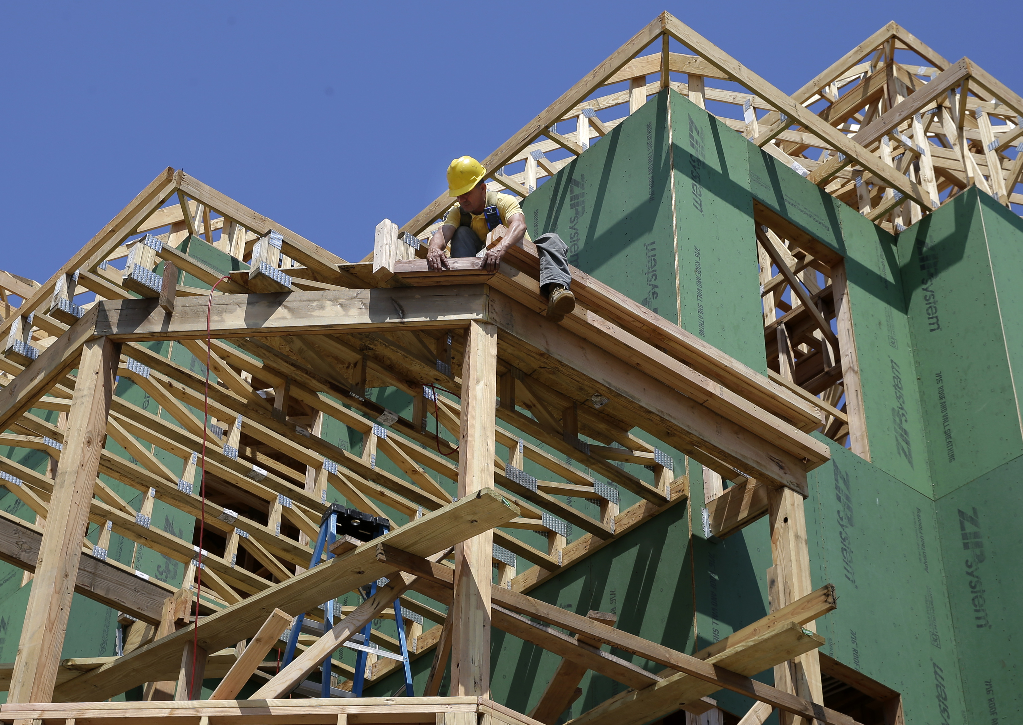 Man works on building a house.<br />(Mel Evans / AP Photo)