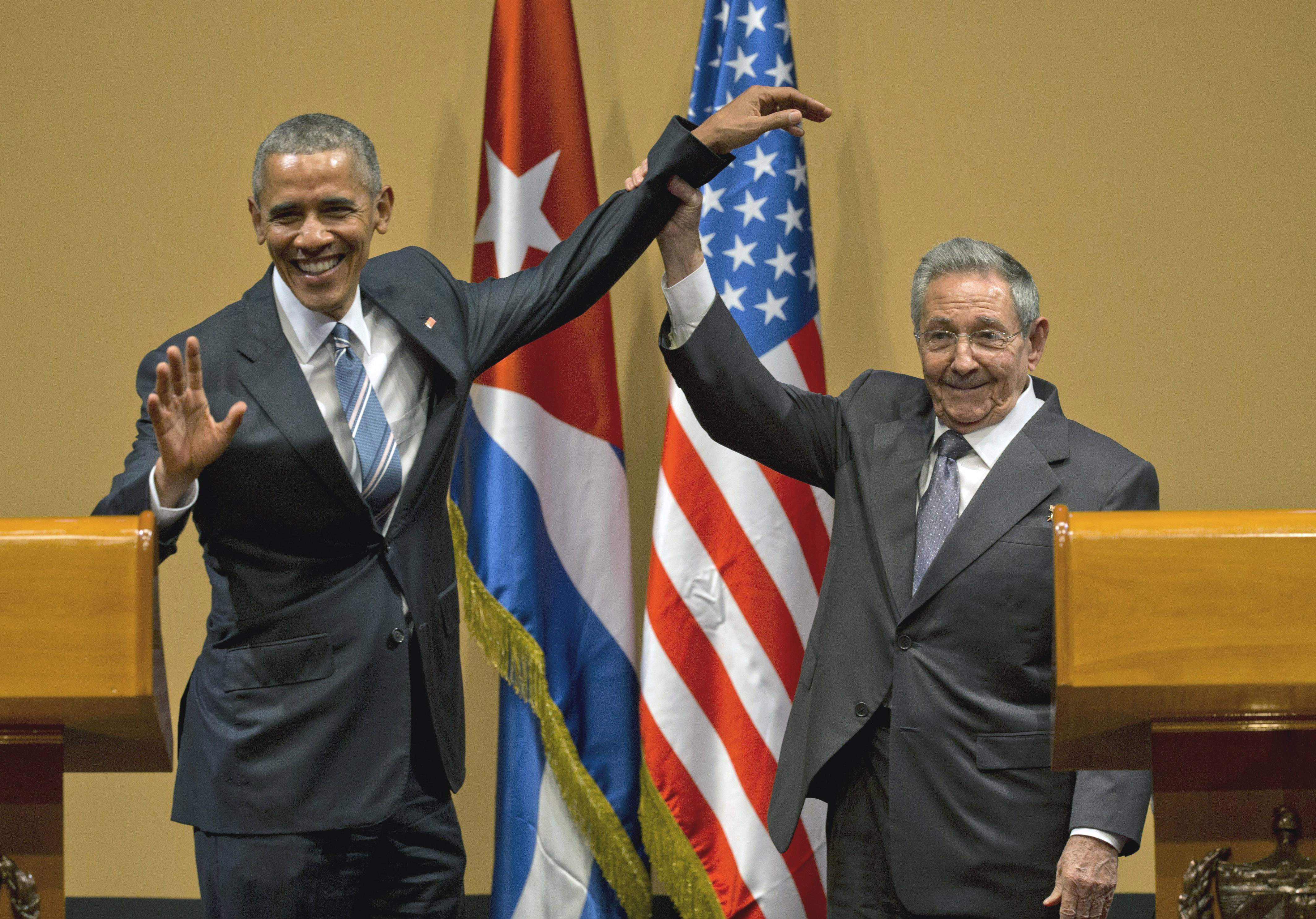 March 21, 2016, former Cuban President Raul Castro (right) lifts up the arm of President Barack Obama at the conclusion of their joint news conference at the Palace of the Revolution in Havana, Cuba. Brushing off decades of distrust, Obama and Castro shook hands, a remarkable moment for two countries working to put the bitterness of their Cold War-era enmity behind them.<br />(Ramon Espinosa / AP Photo)