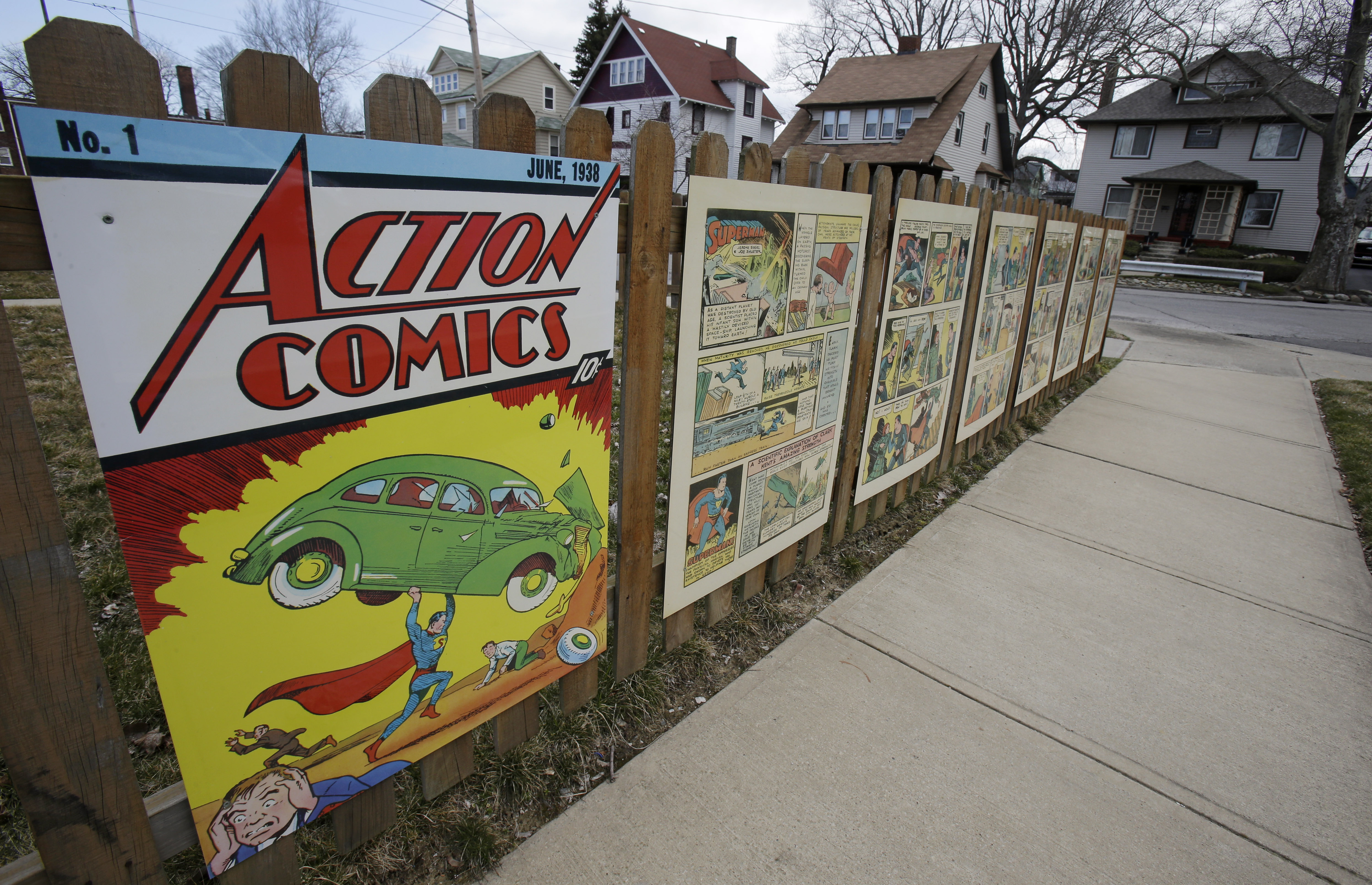 Oversized Superman comic book pages displayed on a fence outside of what was once Joe Shuster&#039;s boyhood home in Cleveland. Superman collaborators Jerry Siegel and Shuster lived several blocks apart in the Glenville neighborhood which shaped their lives, dreams for the future and their imagery of the Man of Steel.<br />(Tony Dejak / AP Photo)