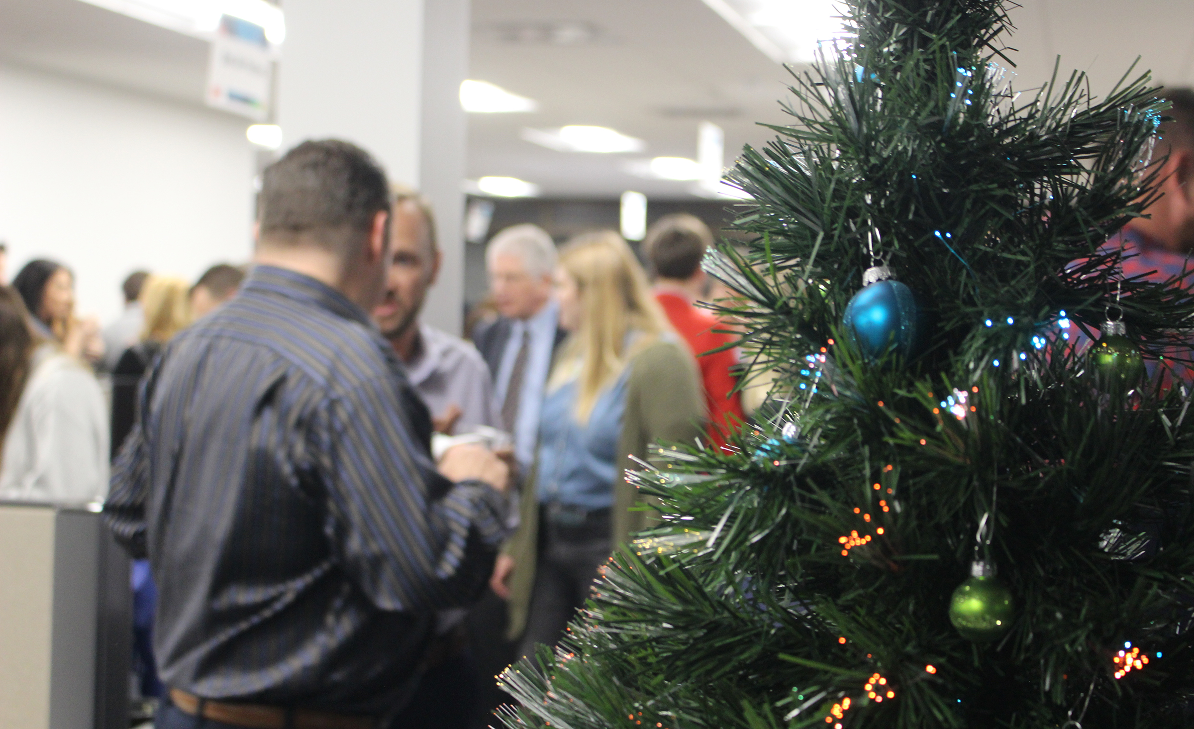 Greater Omaha Chamber members enjoy food, drink and each other’s company by a Christmas tree set up in the chamber offices in downtown Omaha during the Member Appreciation Holiday Open House on Thursday, Dec. 5, 2019. (Photo by Scott Stewart)