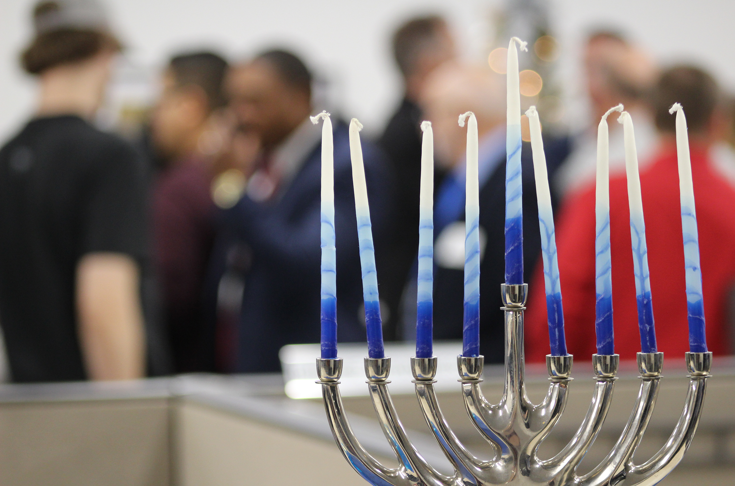 Greater Omaha Chamber members enjoy food, drink and each other’s company near a meno-rah set up in the chamber offices in downtown Omaha during the Member Appreciation Holiday Open House on Thursday, Dec. 5, 2019. (Photo by Scott Stewart)