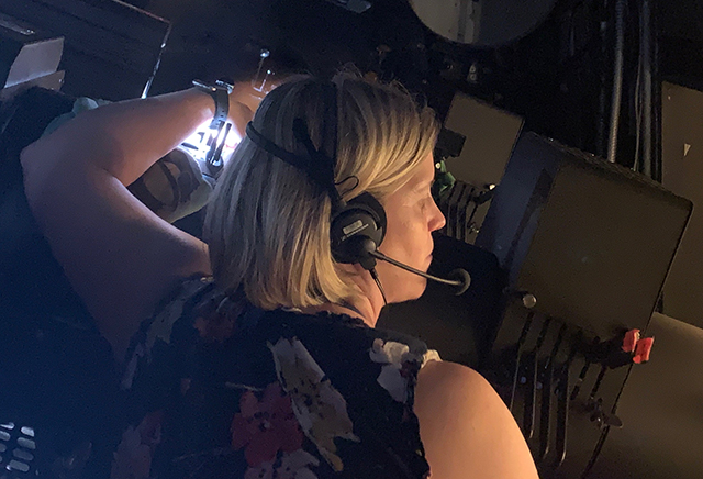 Creighton Law alumna Jamie Bell works a spotlight at the Orpheum Theater in Omaha. (Courtesy Creighton University)
