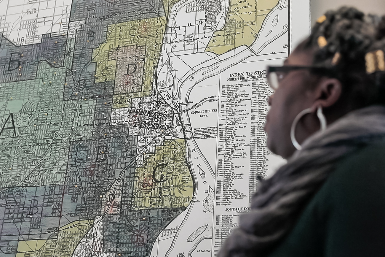 Schmeeka Simpson, who served on the University of Nebraska at Omaha’s Redlining Community Engagement Service Learning Board, looks at a redlining map of Omaha. A film called “Divisible” dug into the practice and how color-coded maps that ranked so-called desirable areas impacted segregation, housing patterns and access to education, health care and more.<br />(Courtesy of Equity Media)