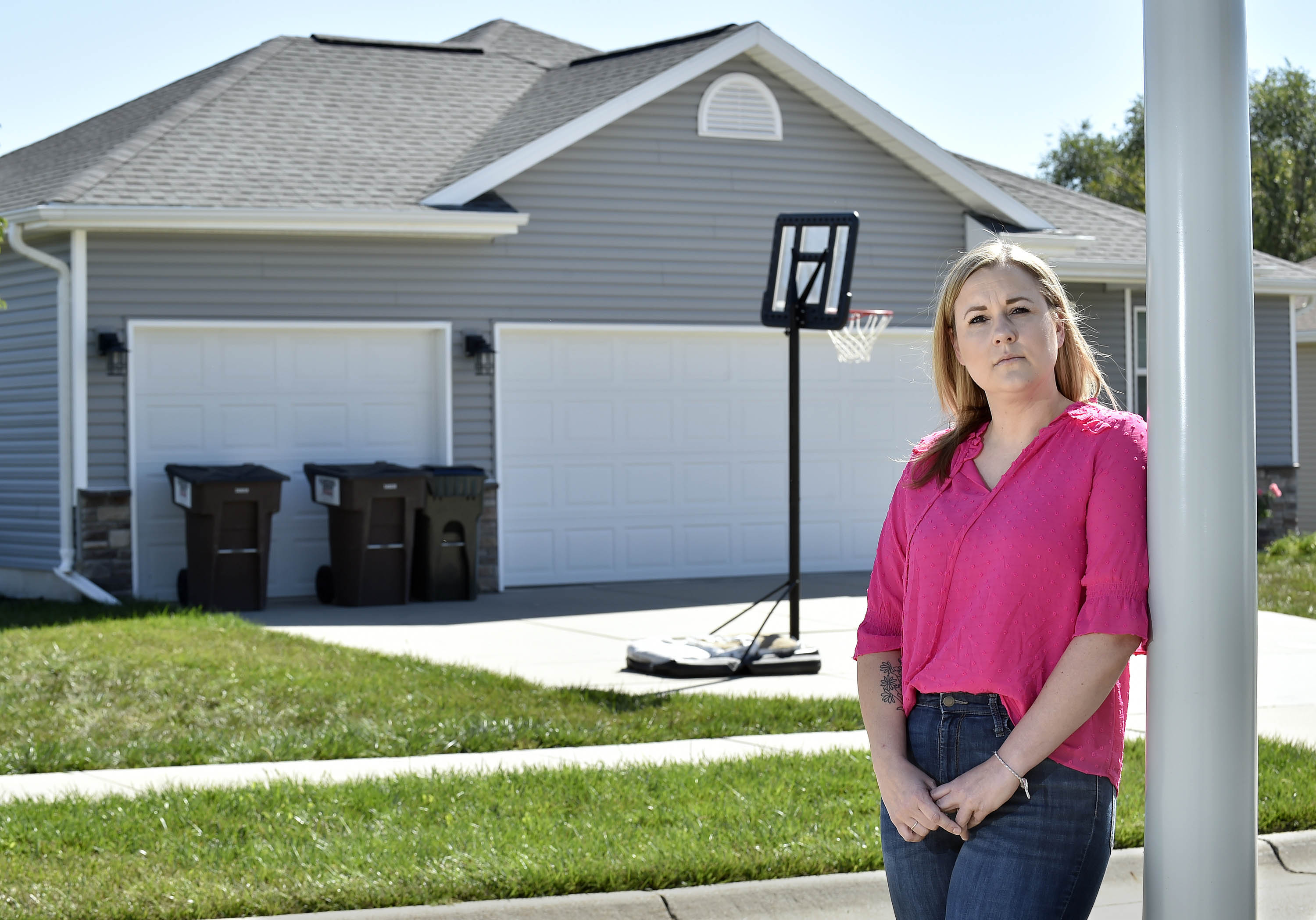 Jenn Burruss stands outside her home in Hickman, Nebraska, Sunday, Sept. 24. Burruss was shocked recently when she learned that her homeowner’s insurance premium had doubled in one year.<br />(Eric Gregory / Flatwater Free Press)