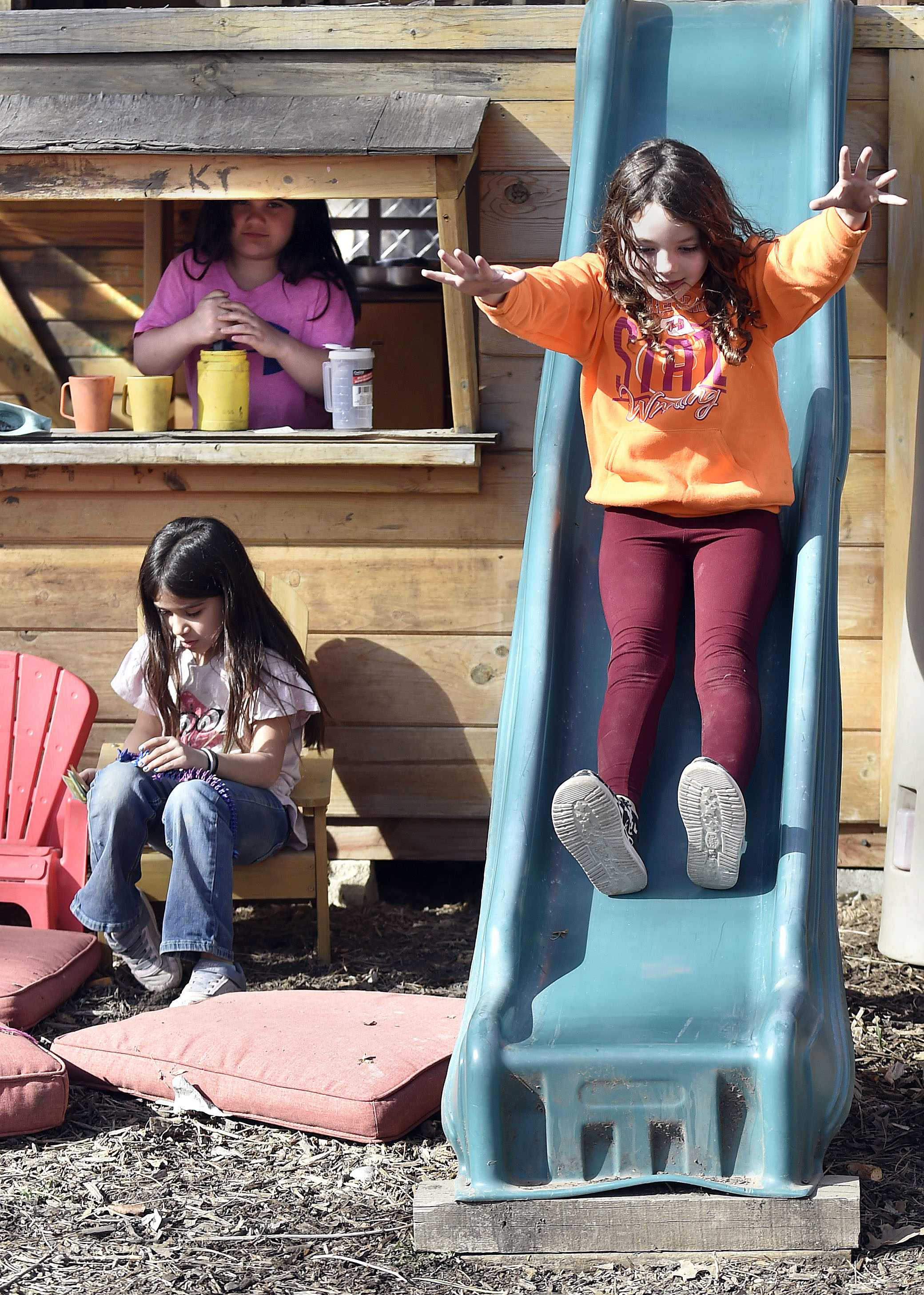 Seven-year-olds Octavia Hampson (clockwise from right) Kyra Medina and Coral Medina hang out at the playhouse at Wild Child Daycare.<br /> (Eric Gregory / Flatwater Free Press)