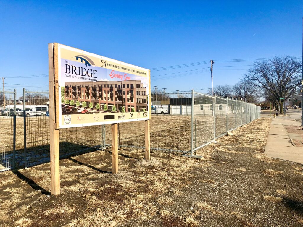 Project site of The Bridge Flats in the Frontier District of Olde Towne Bellevue. A fence surrounds the area, which remains a grassy lot where the old City Hall used to be.  (&lt;a href=&quot;<a href="https://nebraskaexaminer.com/author/cindygonzalez/&quot;&gt;Cindy">https://nebraskaexaminer.com/author/cindygonzalez/&quot;&gt;Cindy</a> Gonzales&lt;/a&gt; / Nebraska Examiner)