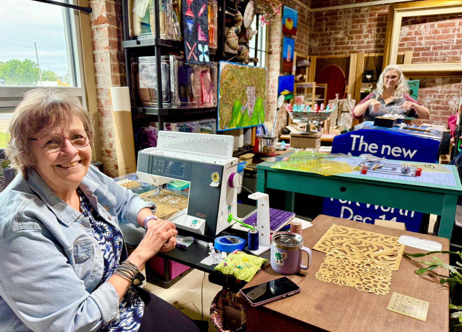 Amy Robertson (forefront) shares an art studio with Letha Goldsmith at Clover24.<br />(Cindy Gonzalez / Nebraska Examiner)