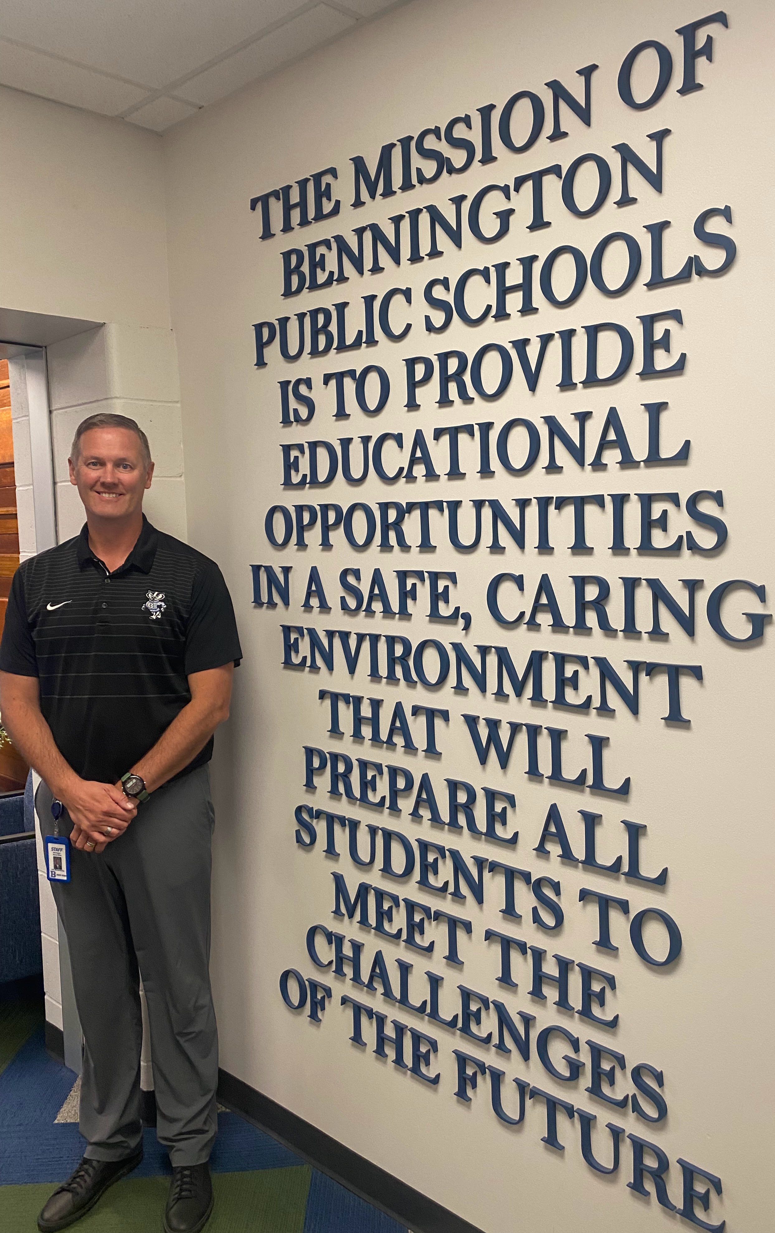 Matt Blomenkamp, Assistant  Superintendent of Operations stands beside the mission statement of Bennington Public Schools.<br />(Don Rashid / The Daily Record)