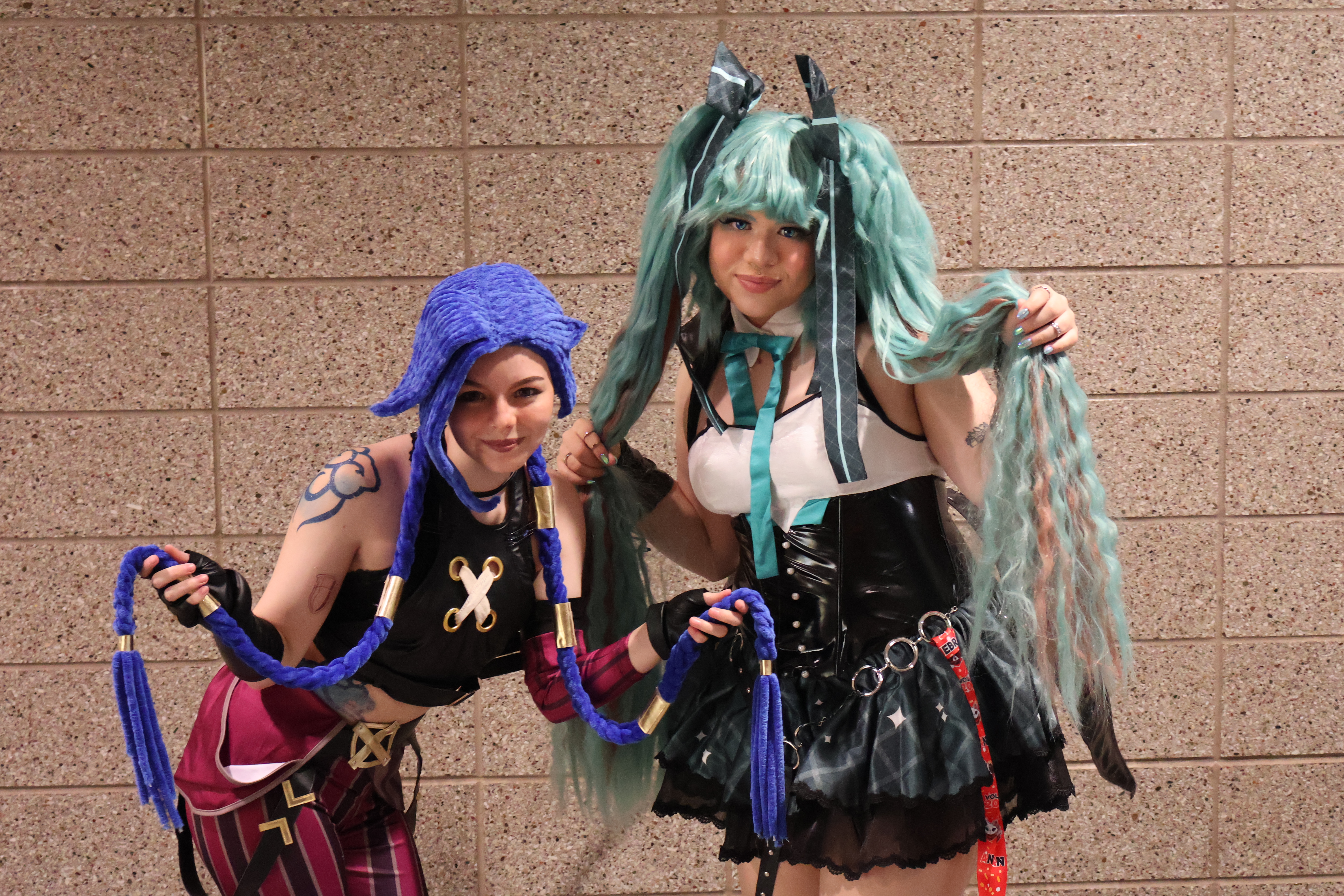 Faith S. (left) and Mira O. on the right showing off their cool cosplays to an awkward journalist in a lavender button-up and purple tie.<br />(Austin Petak / The Daily Record)