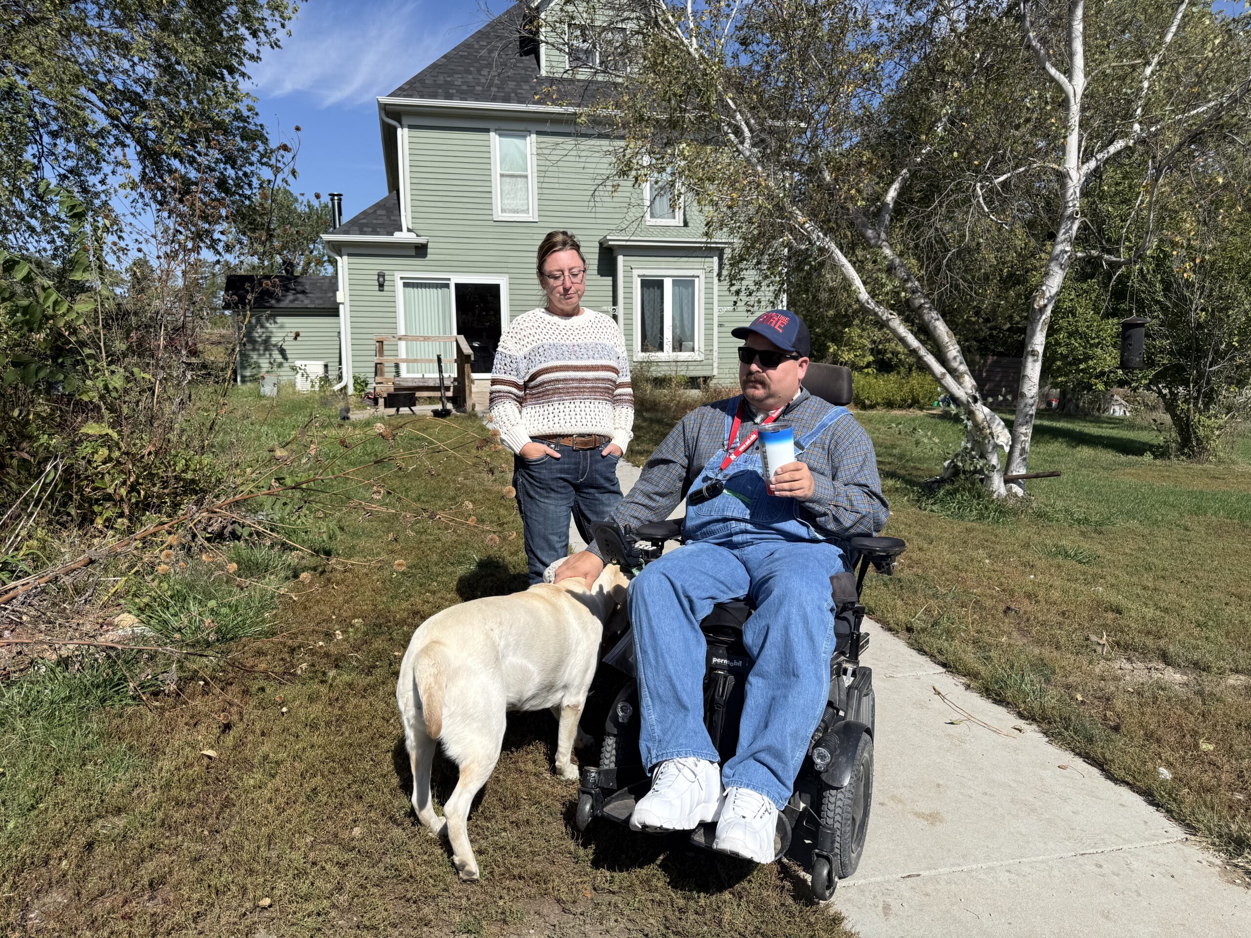 Amanda and Eric Fass and dog Daisy outside their Syracuse area farmhouse.<br />(Cindy Gonzalez / Nebraska Examiner)
