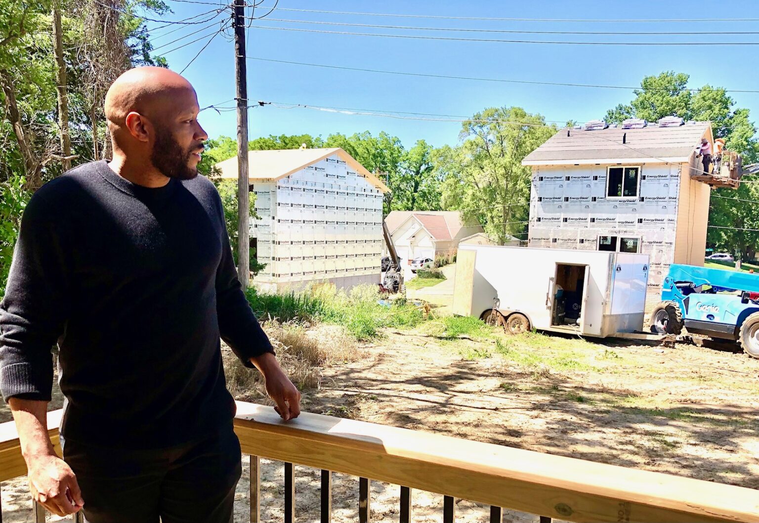 Phillip McClain, on the deck of one of the nine residences he developed as the Curtis Corner project, looks at progress on other residences. It was his first “full-on, new construction project,” he said, giving credit to Spark Developer Academy for helping him launch his company.<br />(Cindy Gonzalez / Nebraska Examiner)
