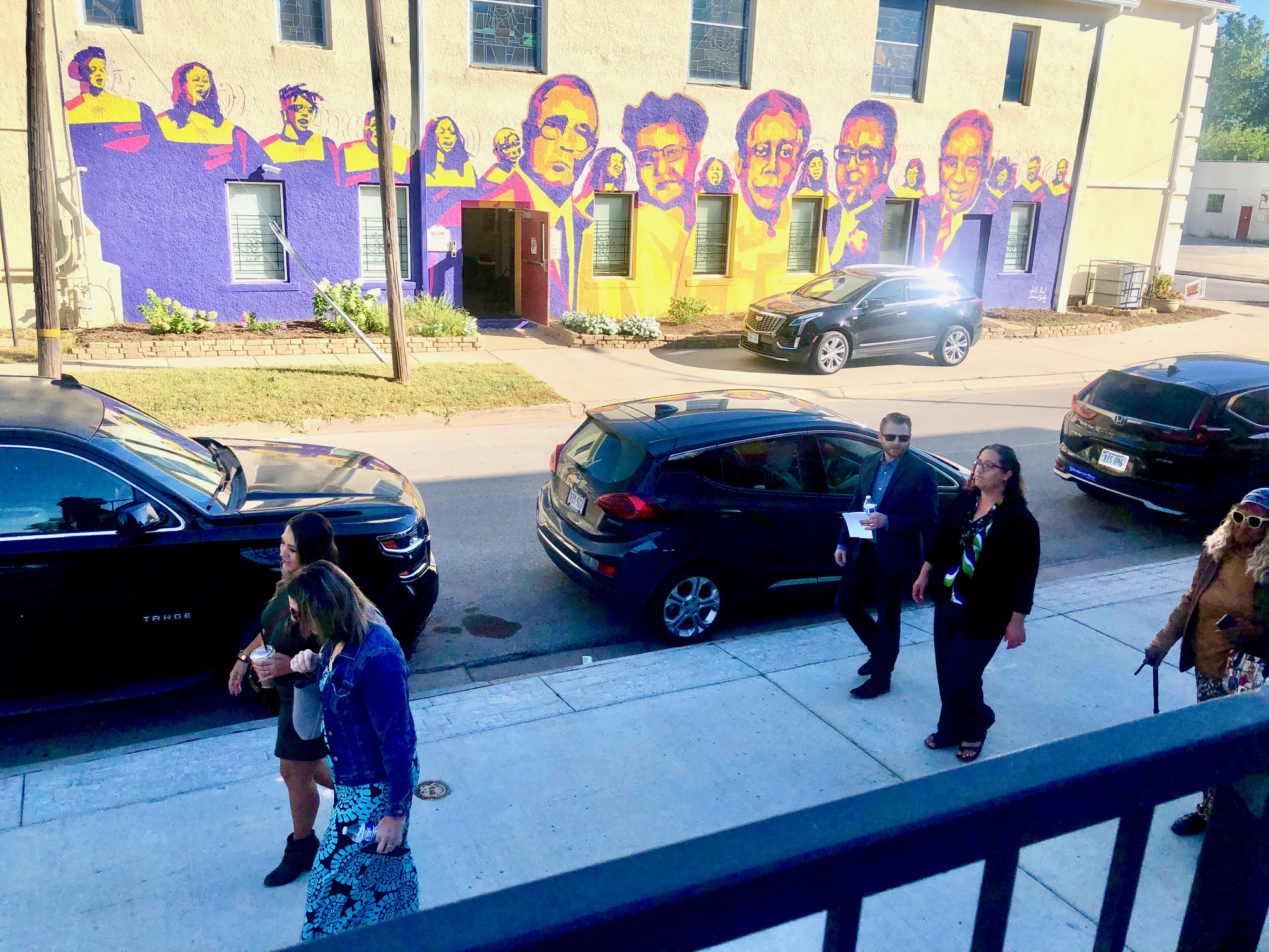 A group walks from an event at the Fabric Lab near 24th and Lake Streets, during which Spark announced its new apprenticeship program for emerging developers, to a scarcity in the neighborhood: a cluster of newly built houses near 25th and Ohio Streets.<br />(Cindy Gonzalez / Nebraska Examiner)