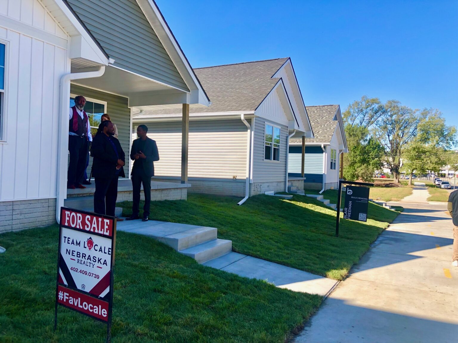 A cluster of newly constructed houses west of the North 24th Street commercial corridor near 25th and Ohio Streets is seen as an example of housing development that could result from a new apprenticeship program launched by Omaha-based nonprofit Spark. Buey Ray Tut, Spark CEO, stands at the front of a home built by a graduate of the Spark “Developer Academy.”<br />(Cindy Gonzalez / Nebraska Examiner)