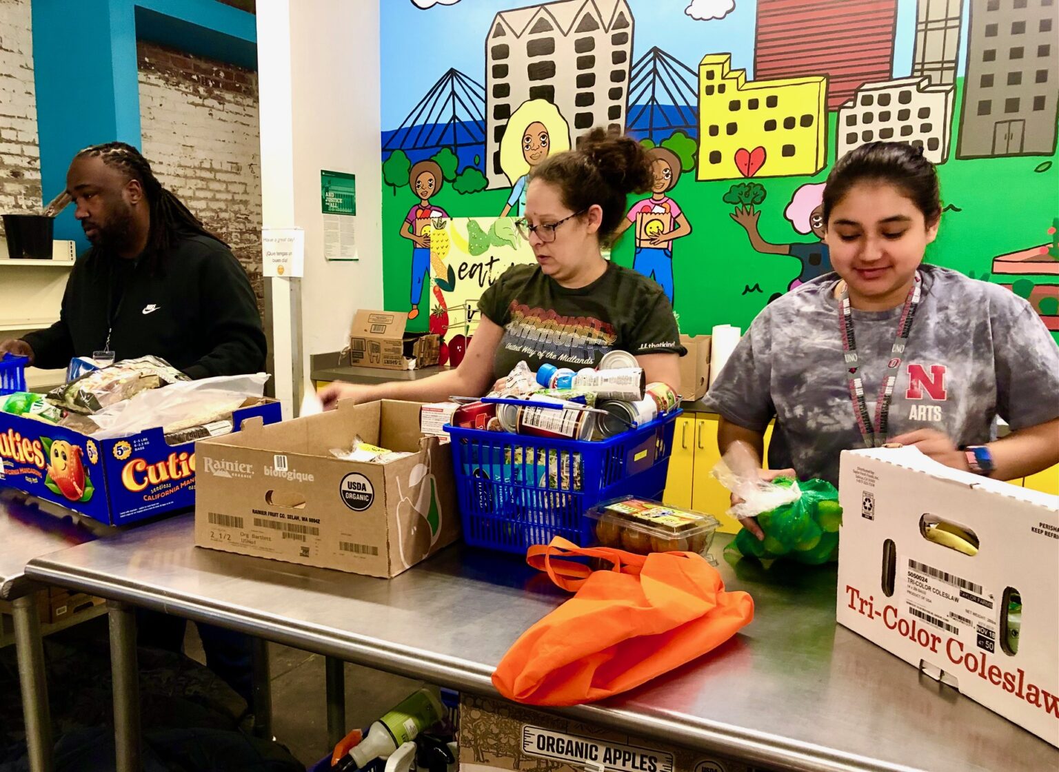 Volunteers and staff at the Together food pantry in downtown Omaha help people in need pack up their free grocery items this week.<br /> (Cindy Gonzalez / Nebraska Examiner)