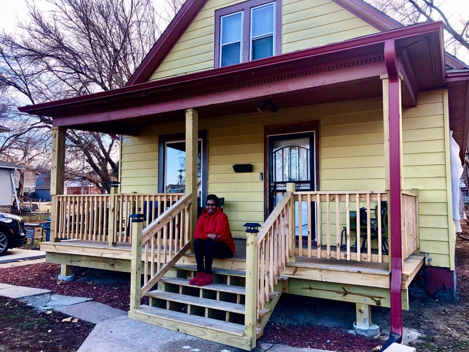 Mitzi Johnson sits on the new front porch of her North Omaha home that was improved with help from a zero-interest home renovation loan provided through the Greenlining Fund of Front Porch Investments. The fund is an effort to help reverse lingering negative effects of historic redlining and racially-biased credit practices.<br />(Cindy Gonzalez / Nebraska Examiner)