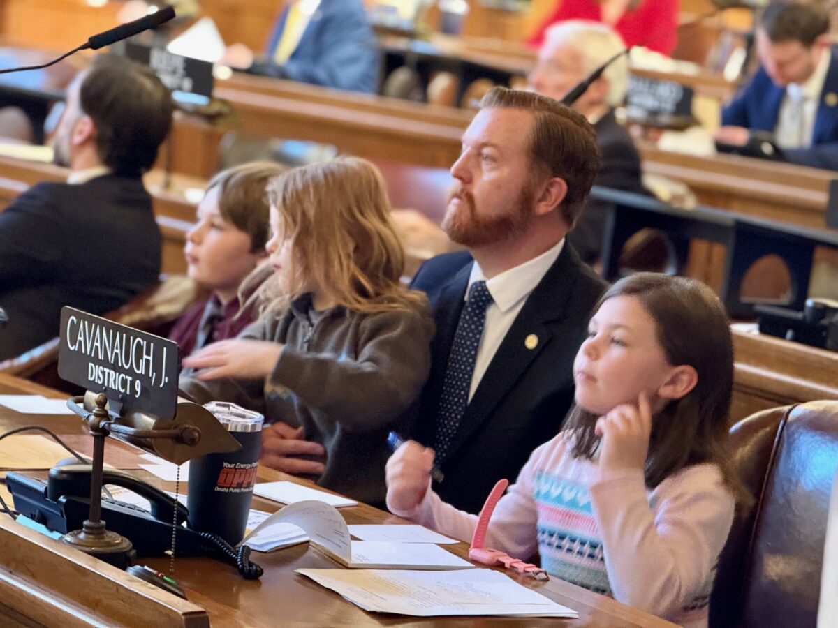 State Sen. John Cavanaugh of Omaha sits with children Jack, William and Lucy during the opening day of the 2025 legislative session, which drew many family and friends.<br />(Cindy Gonzalez / Nebraska Examiner)