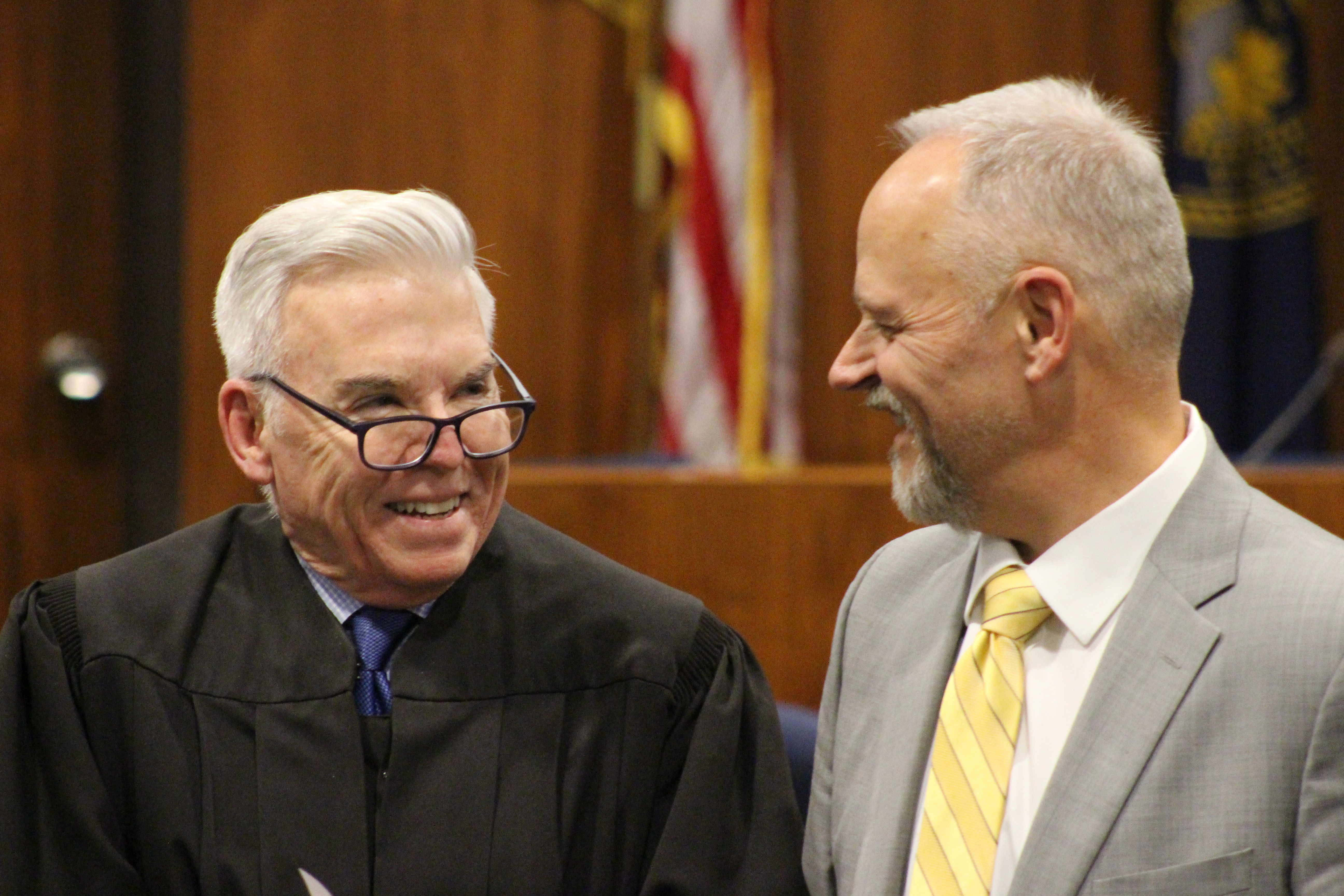Douglas County District Court Judge Gary Randall, left, smiles at Paul Yakel, the former Douglas County Adult Drug Court coordinator, during Yakel’s retirement celebration at the Omaha-Douglas County Civic Center on Dec. 11, 2019. (Scott Stewart/Daily Record)
