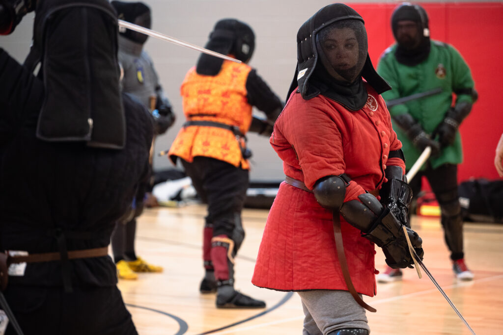 Morgan Otte readies a stance to deflect her opponent’s swing during a training exercise at the Nebraska Swordfighters Guild’s Fight Camp in January. Otte joined the Lincoln-based guild in 2023.<br />(Liz McCue / Flatwater Free Press)