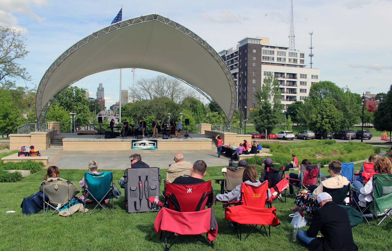 A crowd gathers to watch the blues band Us and Them perform during Legal Aid of Nebraska’s Omaha Gives celebration in Midtown Crossing’s Turner Park on Wednesday, May 23, 2019. (Photo by Scott Stewart)