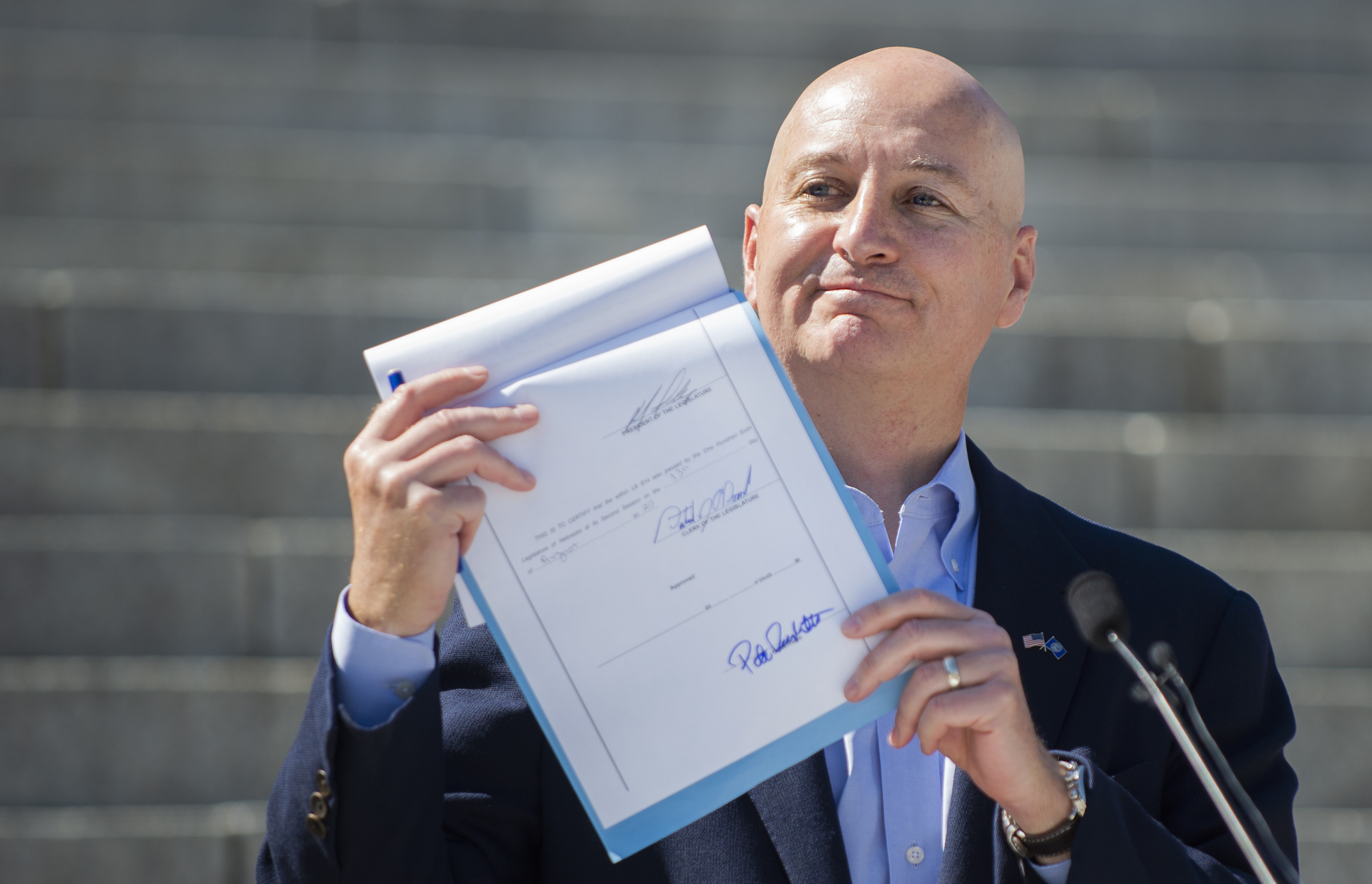 Gov. Pete Ricketts holds up LB 814 after signing it into law on the steps of the state capitol in Lincoln, on Saturday, Aug. 15, 2020. The anti-abortion bill bans what opponents describe as dismemberment abortion in Nebraska. (Kenneth Ferriera/Lincoln Journal Star via AP)