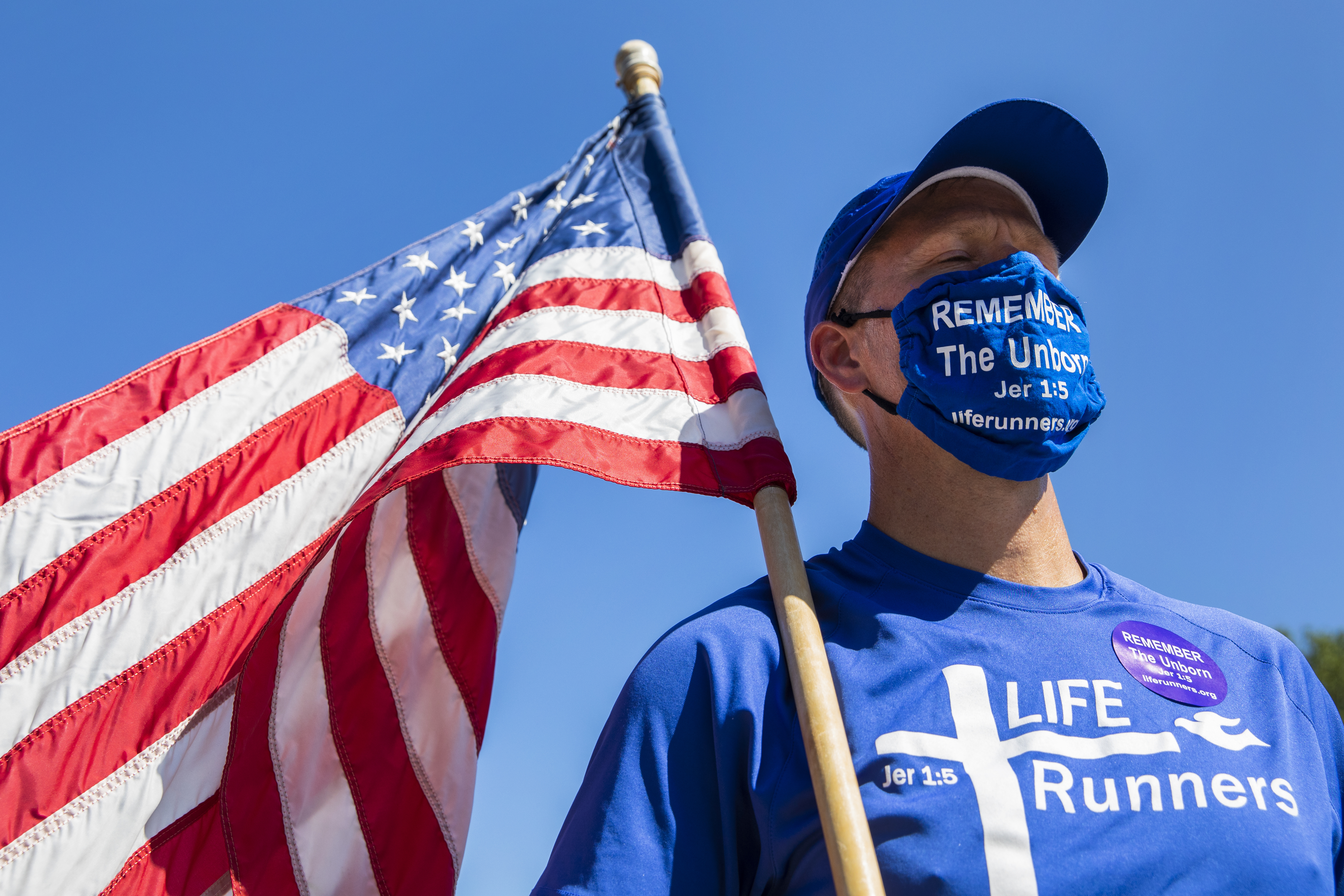 LIFE Runner founder Pat Castle listens to Gov. Pete Ricketts during a ceremony to sign the LB 814 bill at the steps of the state capitol in Lincoln, on Saturday, Aug. 15, 2020. The anti-abortion bill bans dismemberment abortion in Nebraska. (Kenneth Ferriera/Lincoln Journal Star via AP)