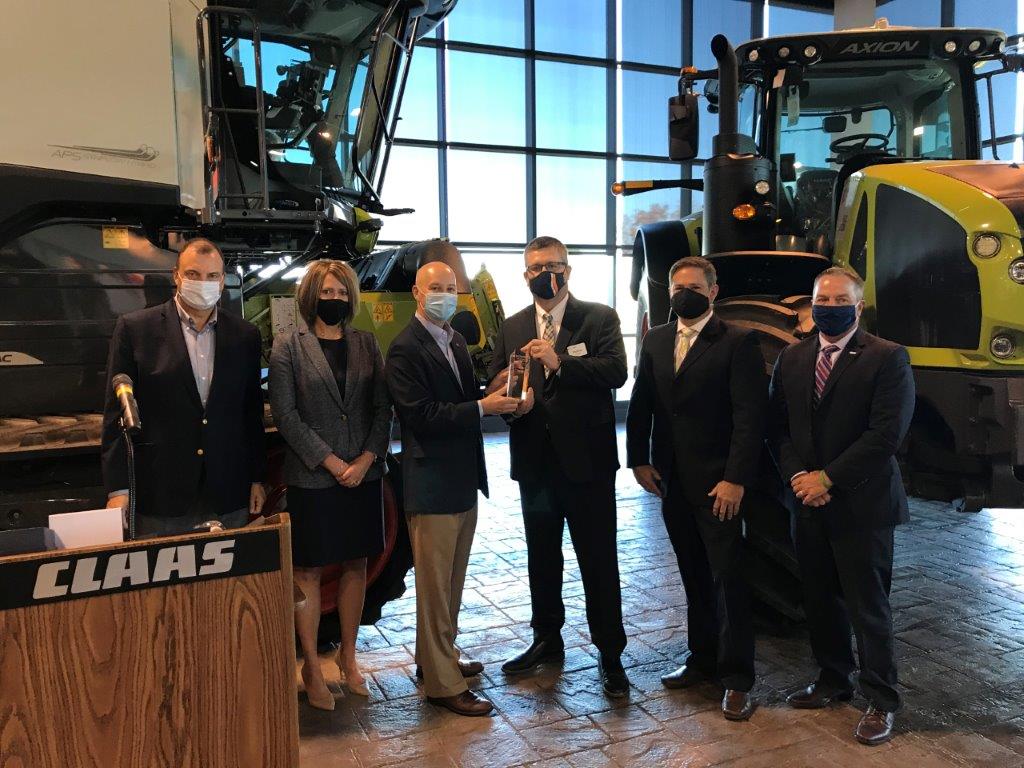 Nebraska Gov. Pete Ricketts, center left, presents the Large Manufacturer of the Year Award to President and Managing Director of Business Administration for CLAAS Omaha Inc. Matthias Ristow during a Manufacturing Month tour Oct. 1, 2020. Also pictured from left are Nebraska Chamber President Bryan Slone, RSM US LLP Partner Michelle Luett. Ricketts, Ristow, CLAAS Omaha Inc. Director of Manufacturing Matthew Koch, and RSM US LLP National Tax Consulting Leader Tony Urban. (Nebraksa Chamber)