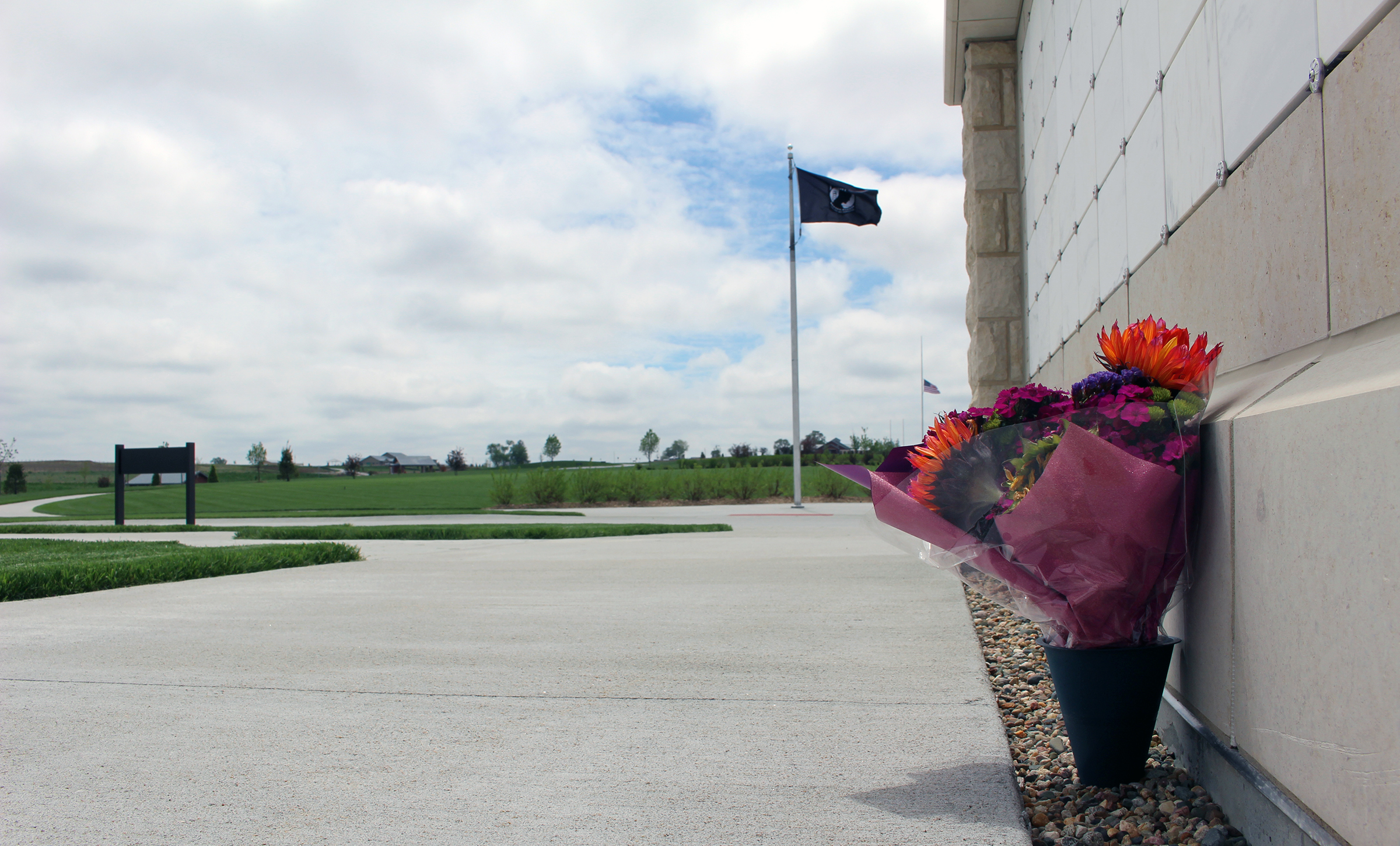 A flag waves in the background at the Omaha National Cemetery outside Papillion on Wednesday, May 20, 2020. (Photo by Scott Stewart)