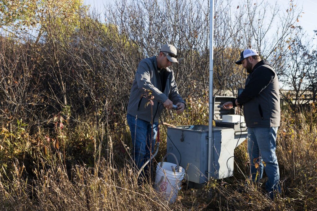 Water resources technicians Josh Schnitzler and Connor Baldwin, who both work for the Lower Elkhorn Resources District in Norfolk, prepare to test the water in a monitoring well near the north fork of the Elkhorn River in 2022. A recent state-led effort to test private wells in Nebraska found 15% had nitrate levels above what the Environmental Protection Agency considers safe.<br />(Ryan Soderlin / Flatwater Free Press)