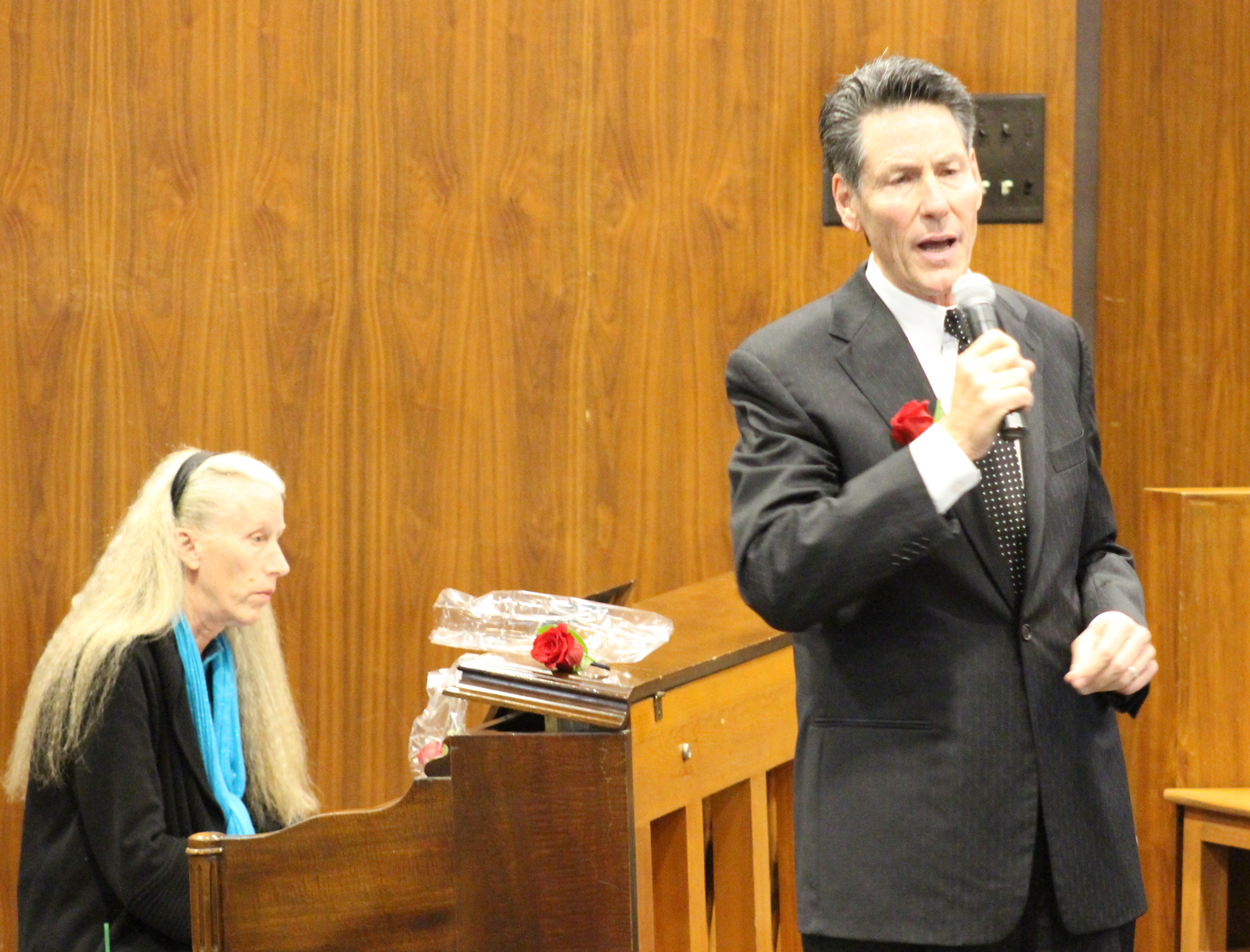 Thomas J. Shomaker of Sodoro Daly Shomaker, right, sings “Shepard Me, O God” with accompaniment by Peg Lacy on the piano during the Omaha Bar Association’s annual Memorial Day Program in the legislative chamber of the Omaha-Douglas Civic Center on May 10, 2019. (Photo by Scott Stewart)