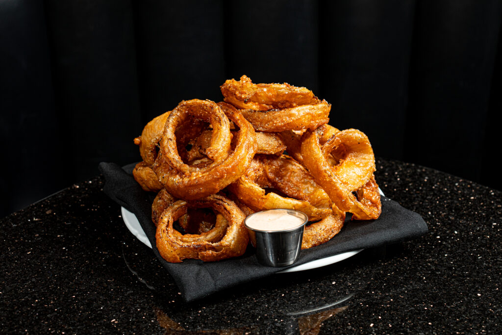Super crispy seasoned onion rings — an update on the restaurant’s original recipe. They are served with chipotle ranch for dipping.<br />(Joshua Foo / Flatwater Free Press)