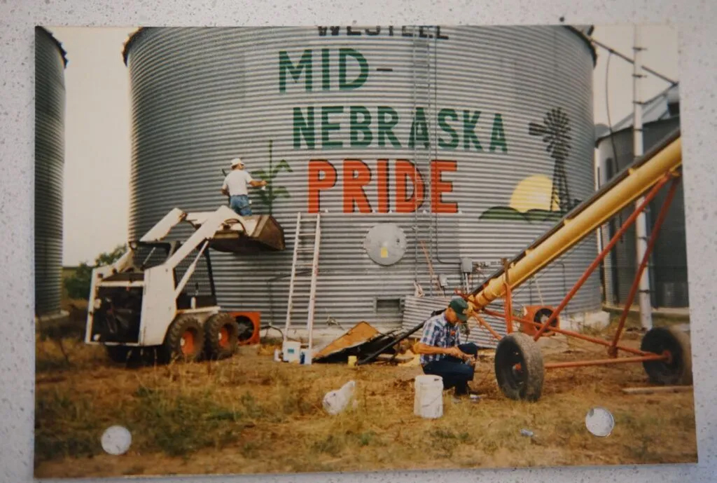 Local residents from more than a dozen Nebraska counties formed Mid-Nebraska PRIDE (People Responding in Defense of our Environment) in the 1990s to advocate for local control in letting hog farms into their communities, including those owned by the family business of Jim Pillen, now Nebraska’s governor. Jim Knopik’s brother-in-law painted Knopik’s grain bin with the group’s name in 1997.<br />(Yanqi Xu / Flatwater Free Press)