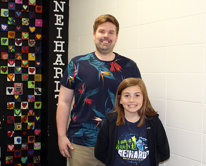Millard Neihardt Elementary School teacher Jeff Sjuts is proud of his student’s first place win in the poster contest. Fifth-grader Tessa Carrell’s poster is displayed on a billboard near 77th and Dodge St. (Photo by Lorraine Boyd)