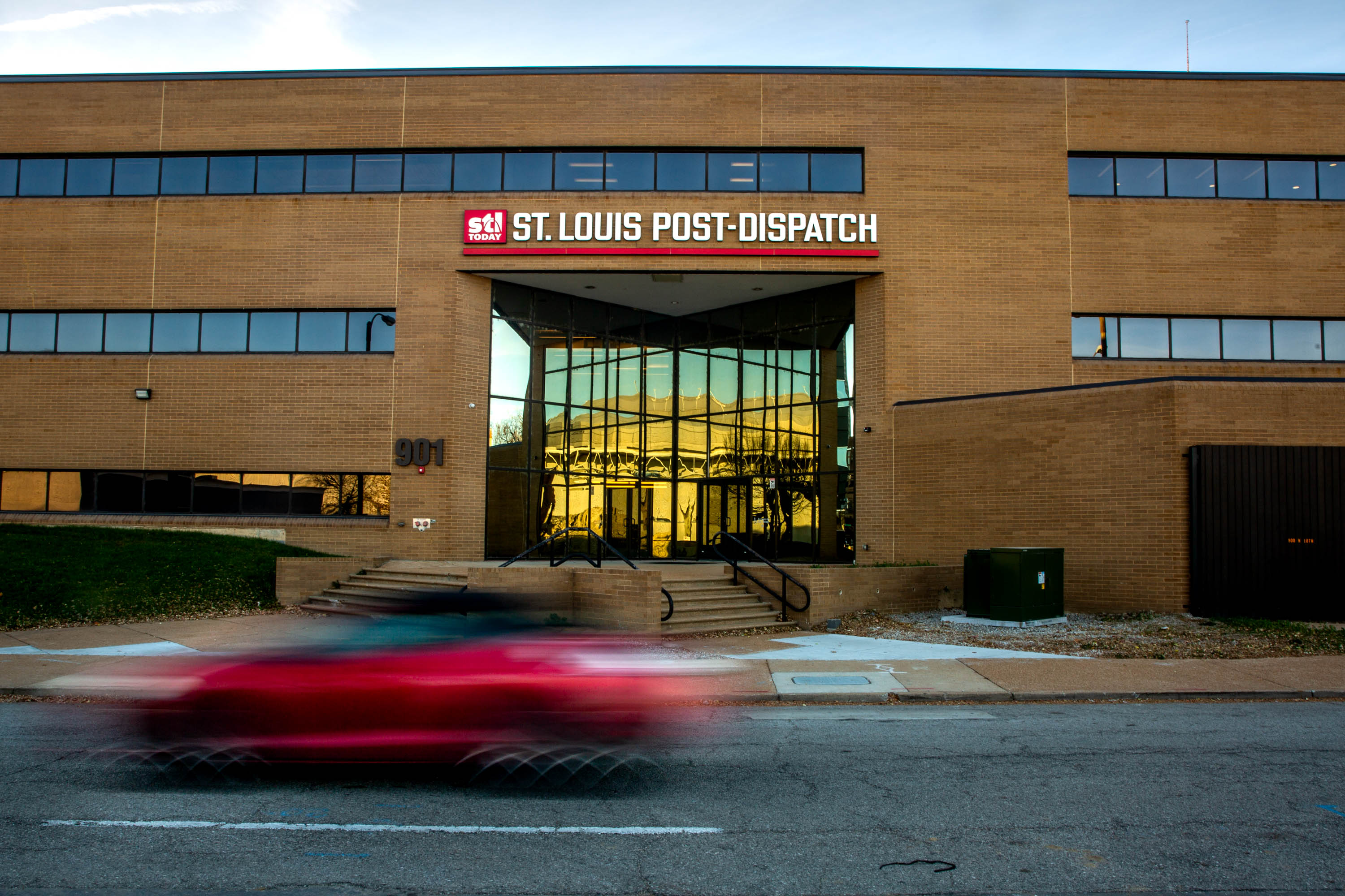 A car zooms past the St. Louis Post-Dispatch headquarters on Dec. 2, 2021, in downtown St. Louis. Lee Enterprises purchased the daily newspaper from Pulitzer Inc. in 2005.<br />(Brian Munoz / St. Louis Public Radio)