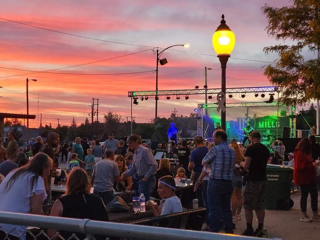 In downtown Sidney, residents gather for “Downtown Sounds,” a monthly summer music event hosted by the Cheyenne County Chamber of Commerce. Cabela’s 2017 departure triggered a staggering 2,000 job losses – nearly one job loss for every three Sidney residents. But Sidney has confounded the most dire predictions for its future in the six years since Cabela’s left. It’s starting to regain some population and diversify its economy, experts say. (Courtesy Photo / Flatwater Free Press)