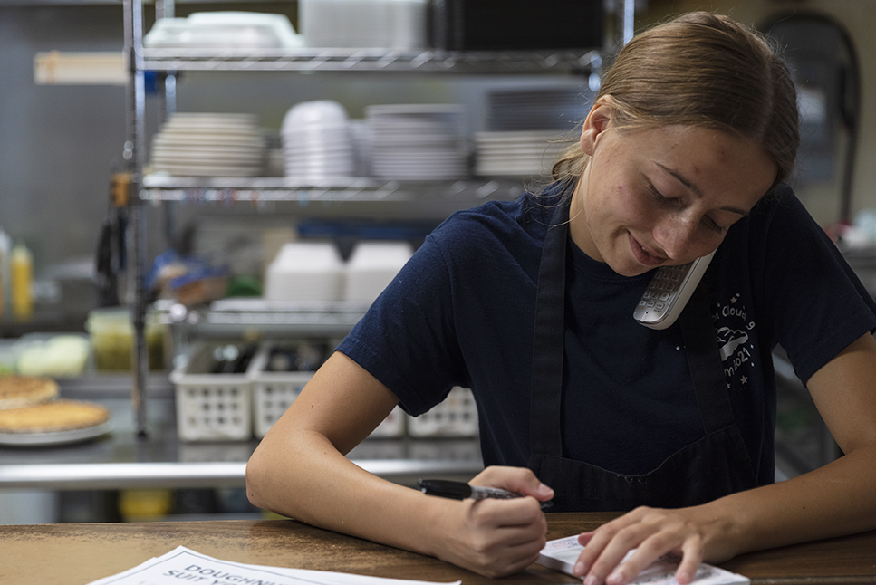 Waitress Morgann Johnson, who is a senior at Boone Central High School, takes a to-go order. (Ryan Soderlin / Flatwater Free Press)