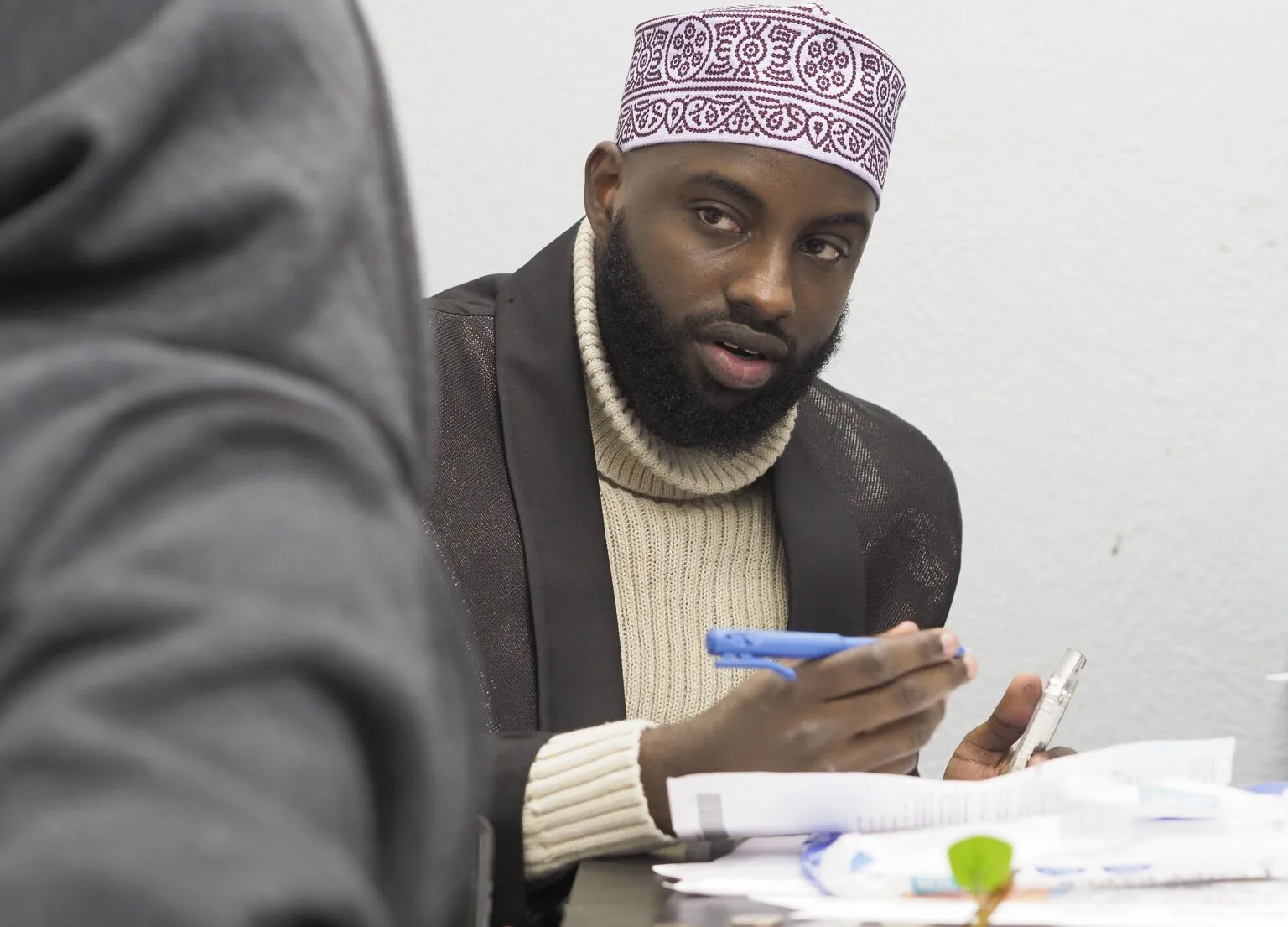 Abdikadir Moalim, founder of the Somali Community of Siouxland, speaks with community member Mohammed Ali on Dec. 15, 2024 at the nonprofit’s office. Moalim works as an interpreter at the nearby Tyson plant in Dakota City.<br />(Jerry L Mennenga / Flatwater Free Press)