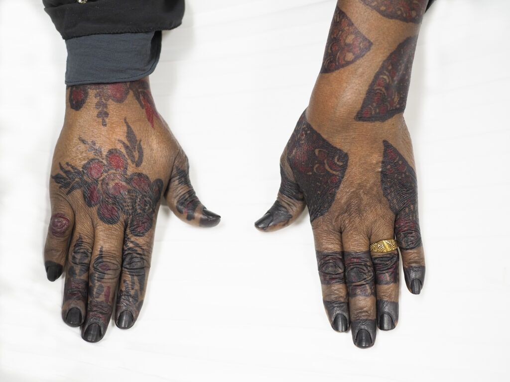 Fadumo Ibad shows off her henna-adorned hands at her shop on Dakota Avenue in South Sioux City. During the week, Ibad works at a childcare center.<br />(Jerry L Mennenga / Flatwater Free Press)