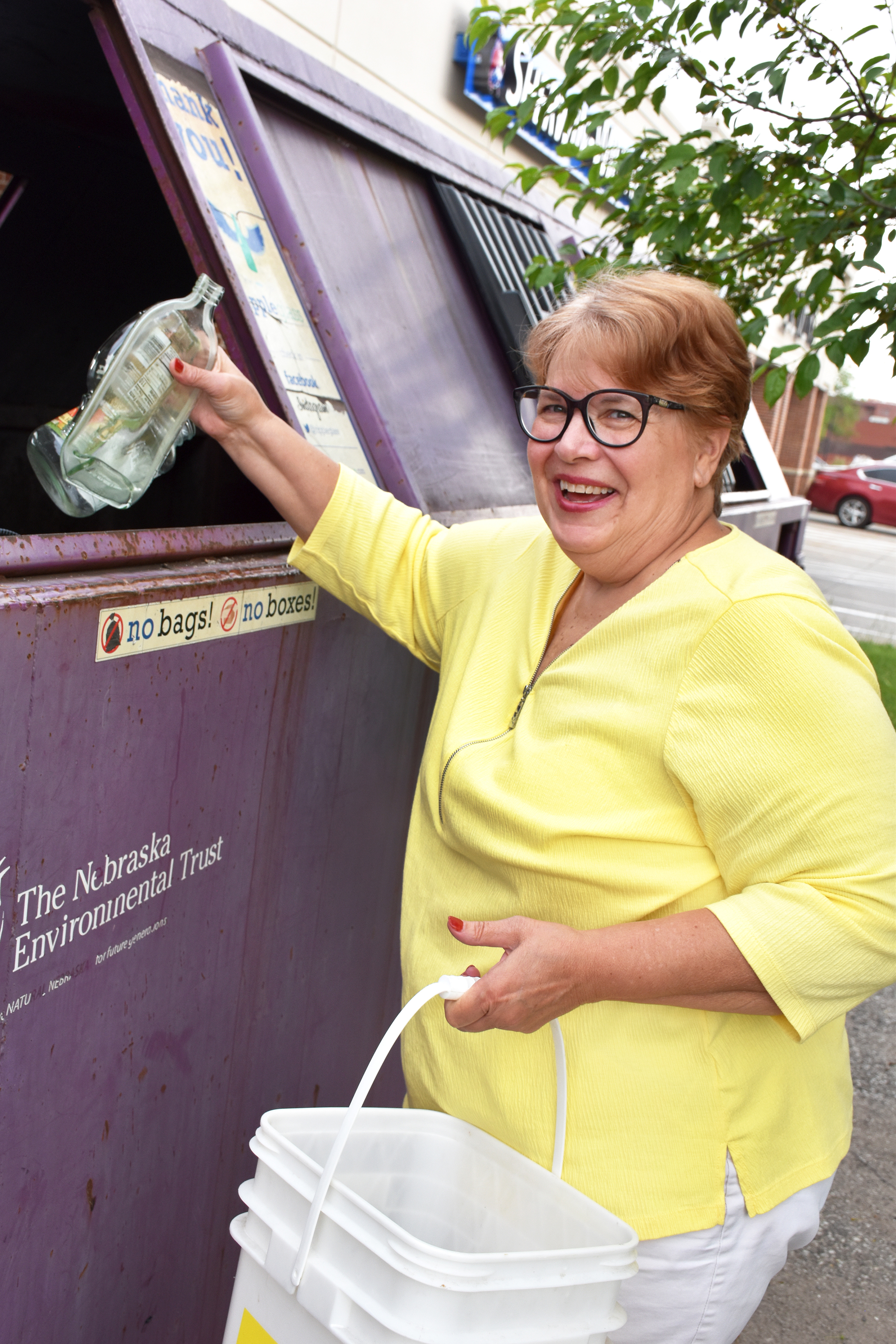 Sue Boyd, an avid recycler, deposits her bottles at one of the eight locations that accept glass from Omaha residents throughout the metro area.<br />(Carla Chance / The Daily Record)