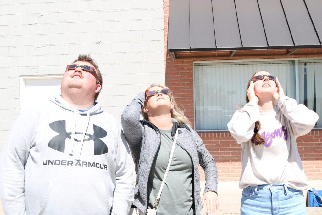 Dakota Cherney (left), TK Hergott and Paige Hansen, now referred to as the Thayer County Three, viewing the solar eclipse from Hebron in April 2024. All three served as Hometown Interns in Thayer County while in college, and all three then moved back to their hometowns after graduating.<br /> (Courtesy photo)