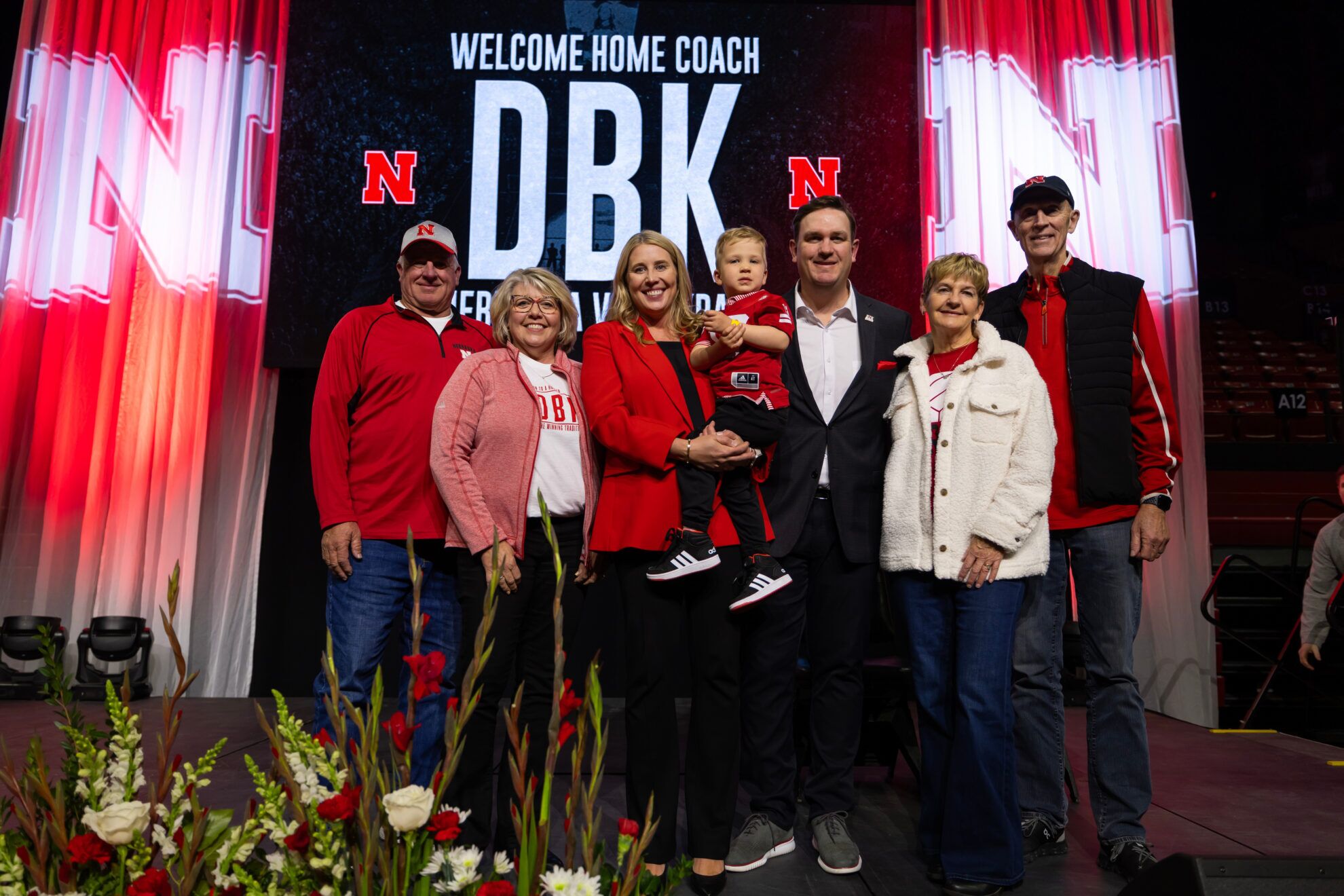 Dani Busboom Kelly and her family on stage at an official introductory event Feb. 6 in the Devaney Center. Busboom Kelly was a standout player for the Huskers in the 2000s before launching into her coaching career.<br />(Courtesy of Nebraska Athletics)