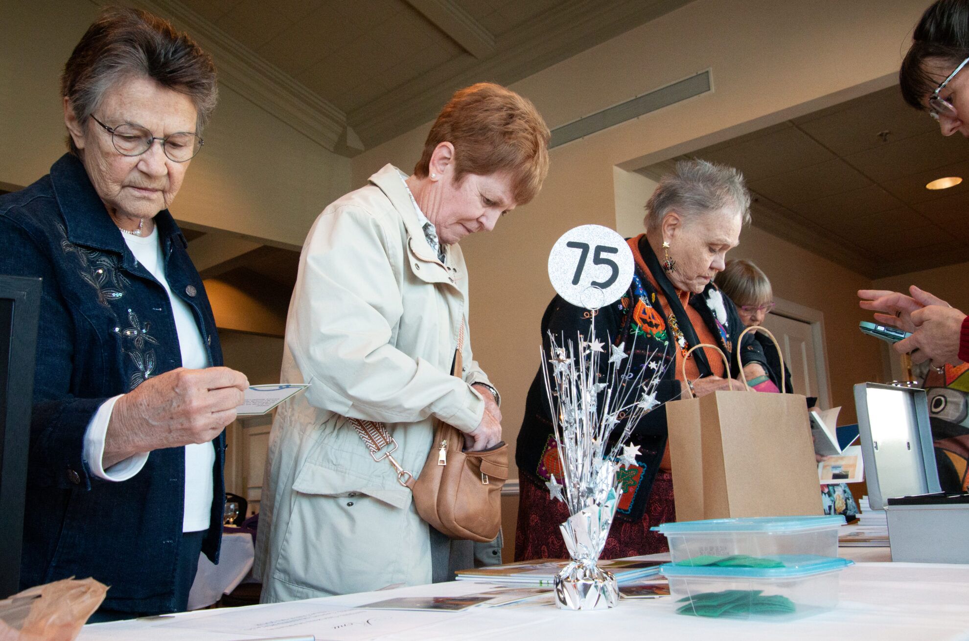 Members of the Eclectic Book Review Club browse books for sale after an October meeting of the 75-year-old Omaha reading group.<br />(Jeremy Turley / Flatwater Free Press)