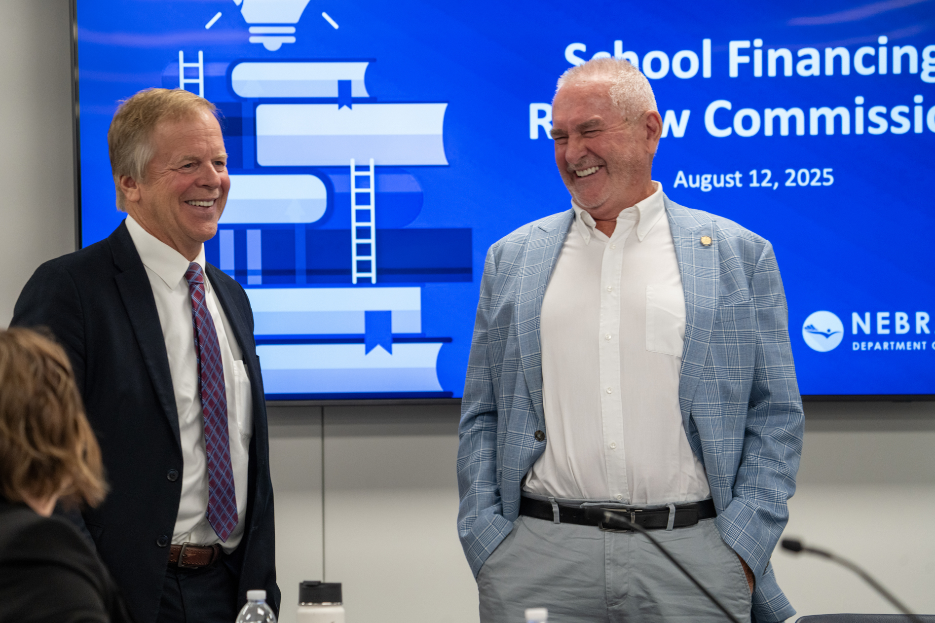 Nebraska State Treasurer Tom Briese of Albion (left)  and State Sen. Dave Murman of Glenvil, chair of the Legislature’s Education Committee, talk during a break of a School Financing Review Commission meeting on Aug. 12, 2025. Briese and Murman attended the 2025 “State of the University of Nebraska” address by NU President Jeffrey Gold on Thursday.<br />(Zach Wendling / Nebraska Examiner)
