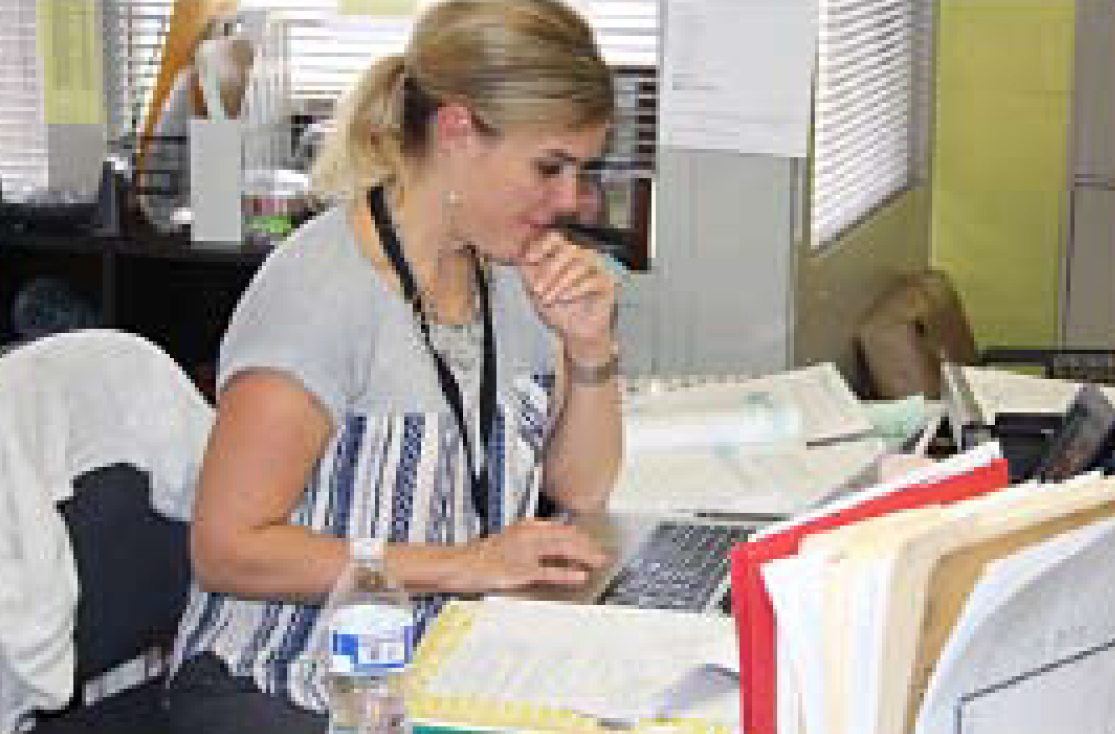 Teacher Marlo Tomich multi-tasks while the sixth-graders brainstormed.