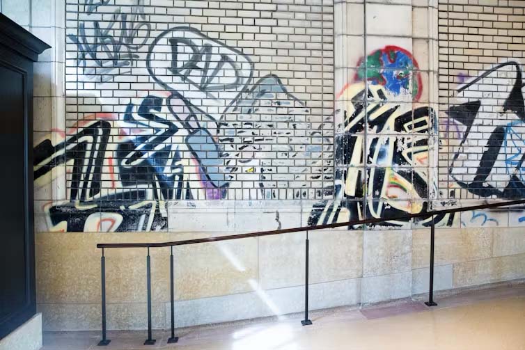 Details from Michigan Central’s era of abandonment, such as this graffiti, were preserved as part of the final restoration.<br />(Amy Sacka / The Conversation)