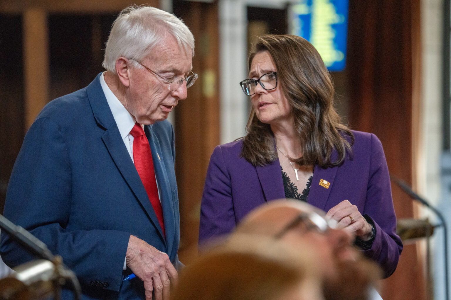 State Sens. Merv Riepe of Ralston and Kathleen Kauth of the Millard area meet on the floor of the Nebraska Legislature, April 22, 2025.<br />(Zach Wendling / Nebraska Examiner)