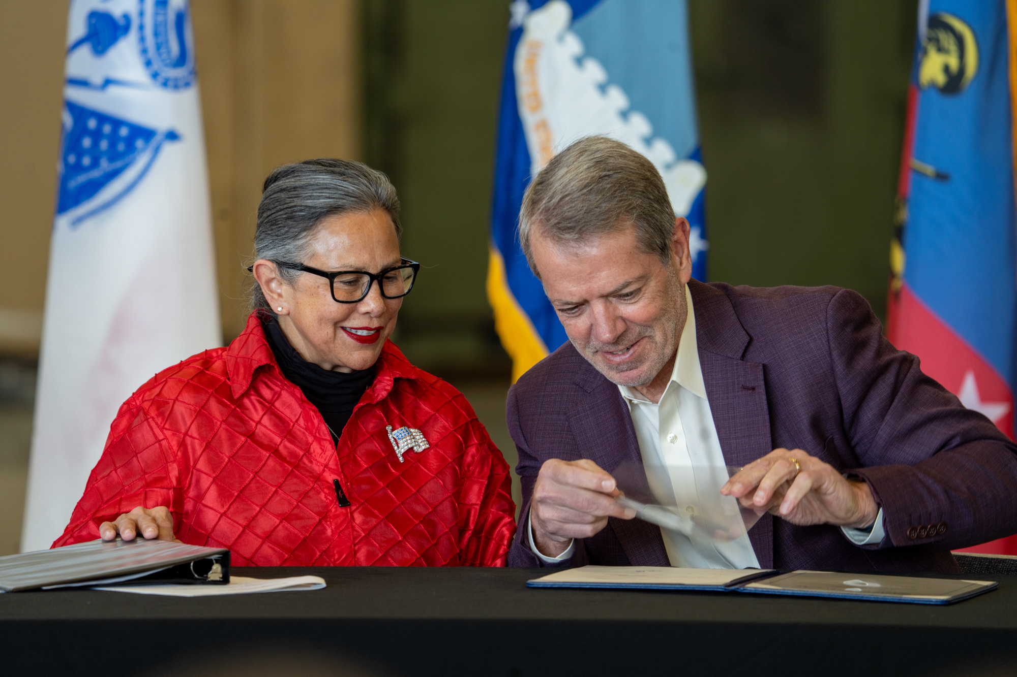 State Sen. Rita Sanders of Bellevue (left) joins Nebraska Gov. Jim Pillen for a ceremonial bill signing of Nebraska National Guard recruitment and retention legislation, Dec. 10, 2024.<br /> (Zach Wendling / Nebraska Examiner)